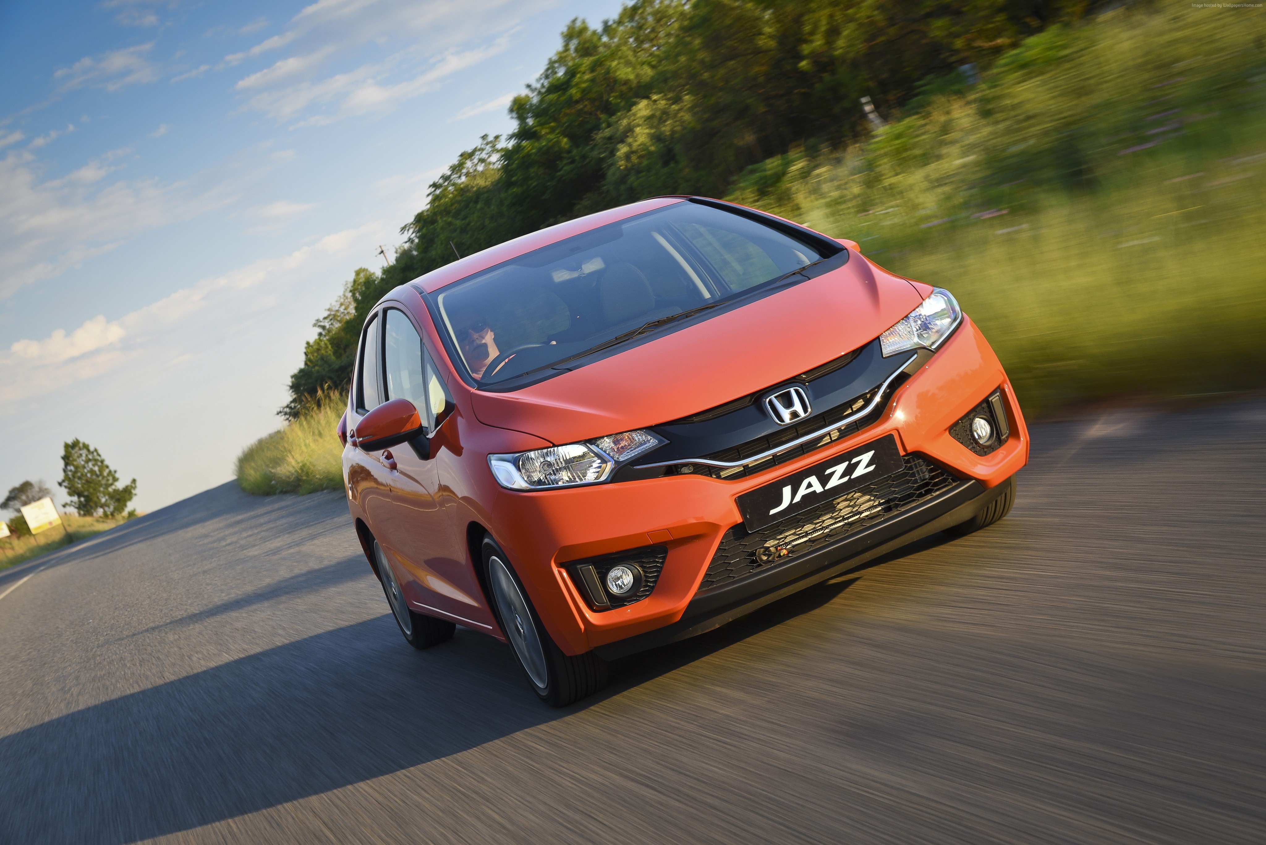 Orange Honda Jazz driving on a road HD Wallpaper