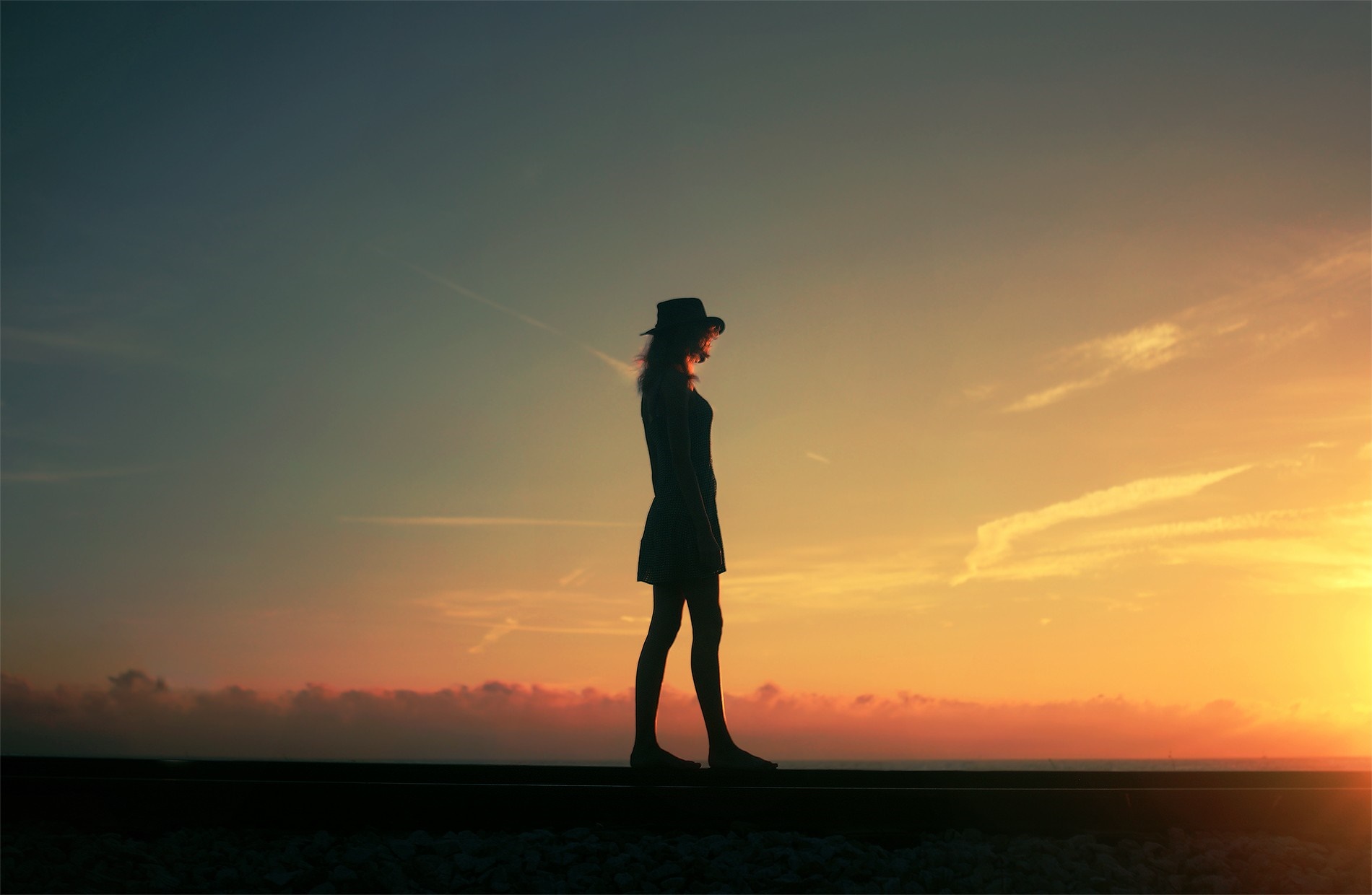 Silhouette of a woman in a hat at sunset HD Wallpaper