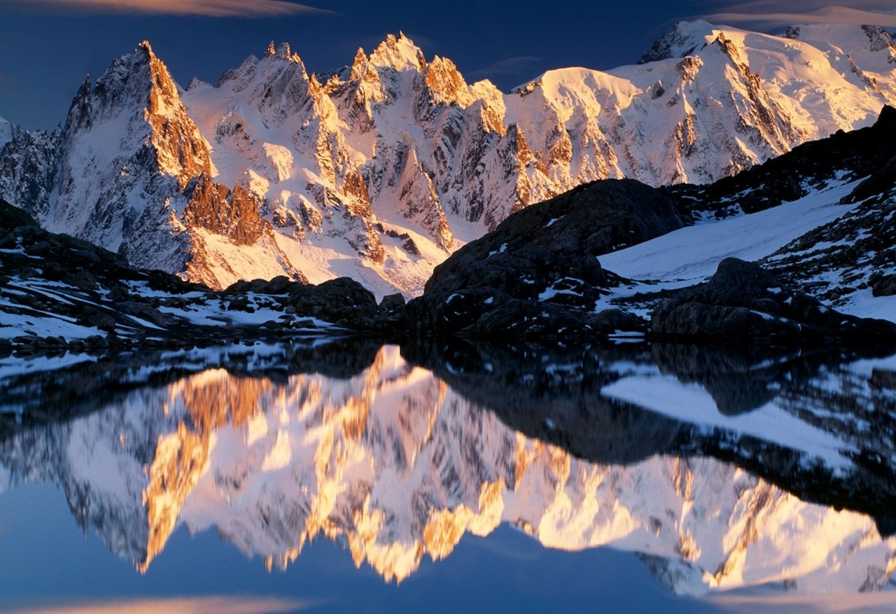 Snowy mountain range reflected in a lake at sunrise HD Wallpaper