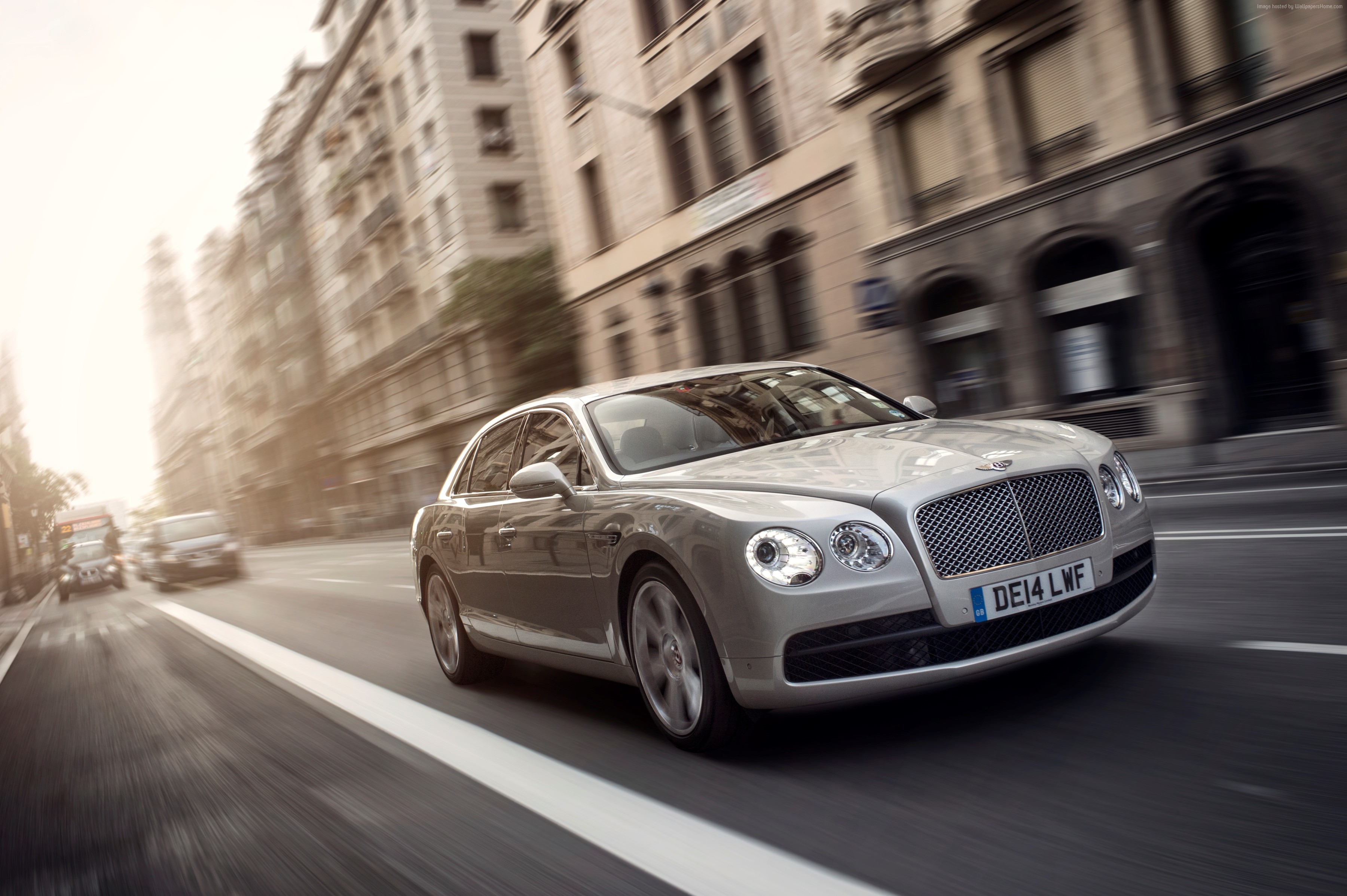 Bentley Flying Spur sedan driving on city street HD Wallpaper