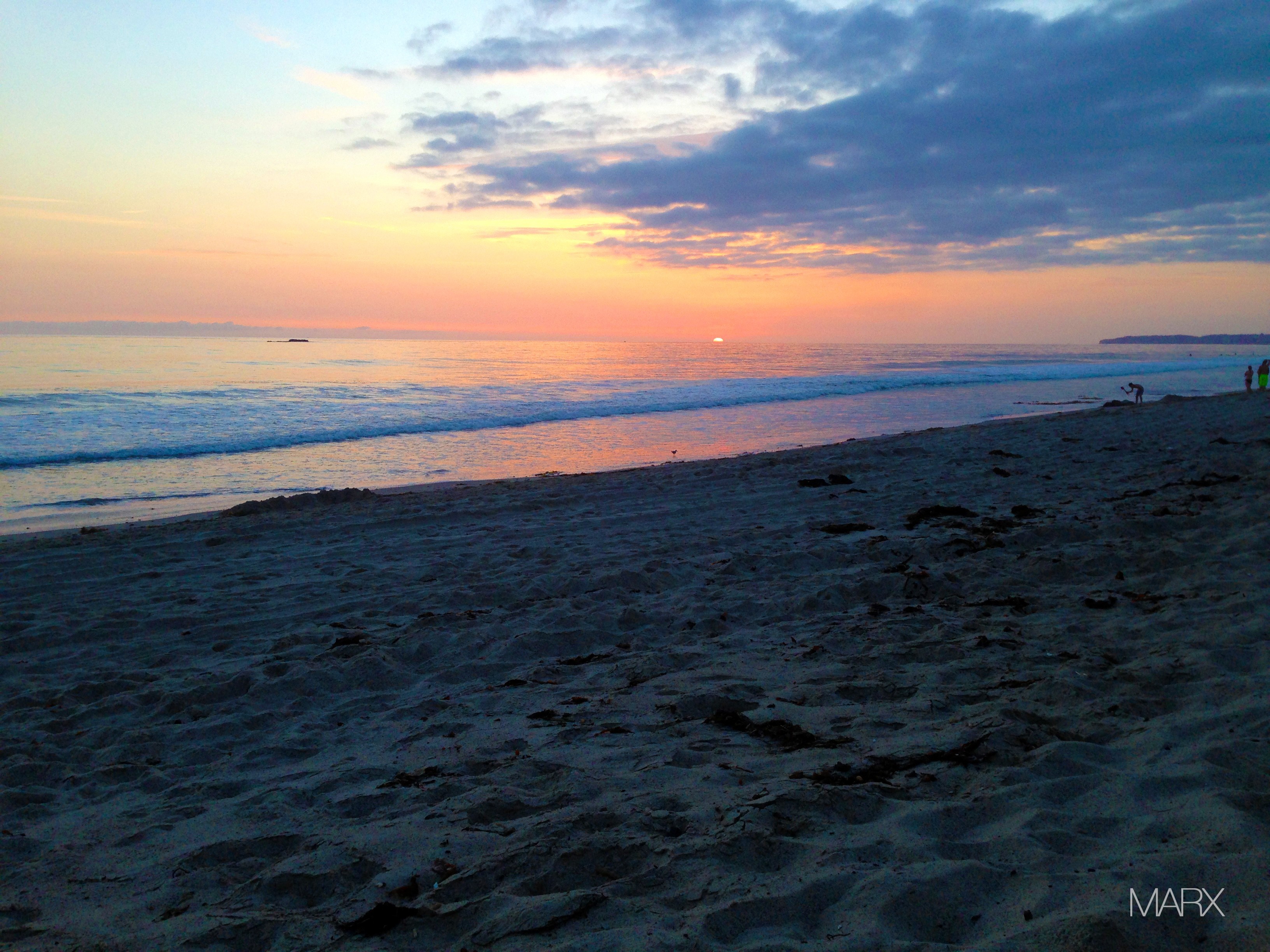 Sunset over the ocean at a sandy beach HD Wallpaper