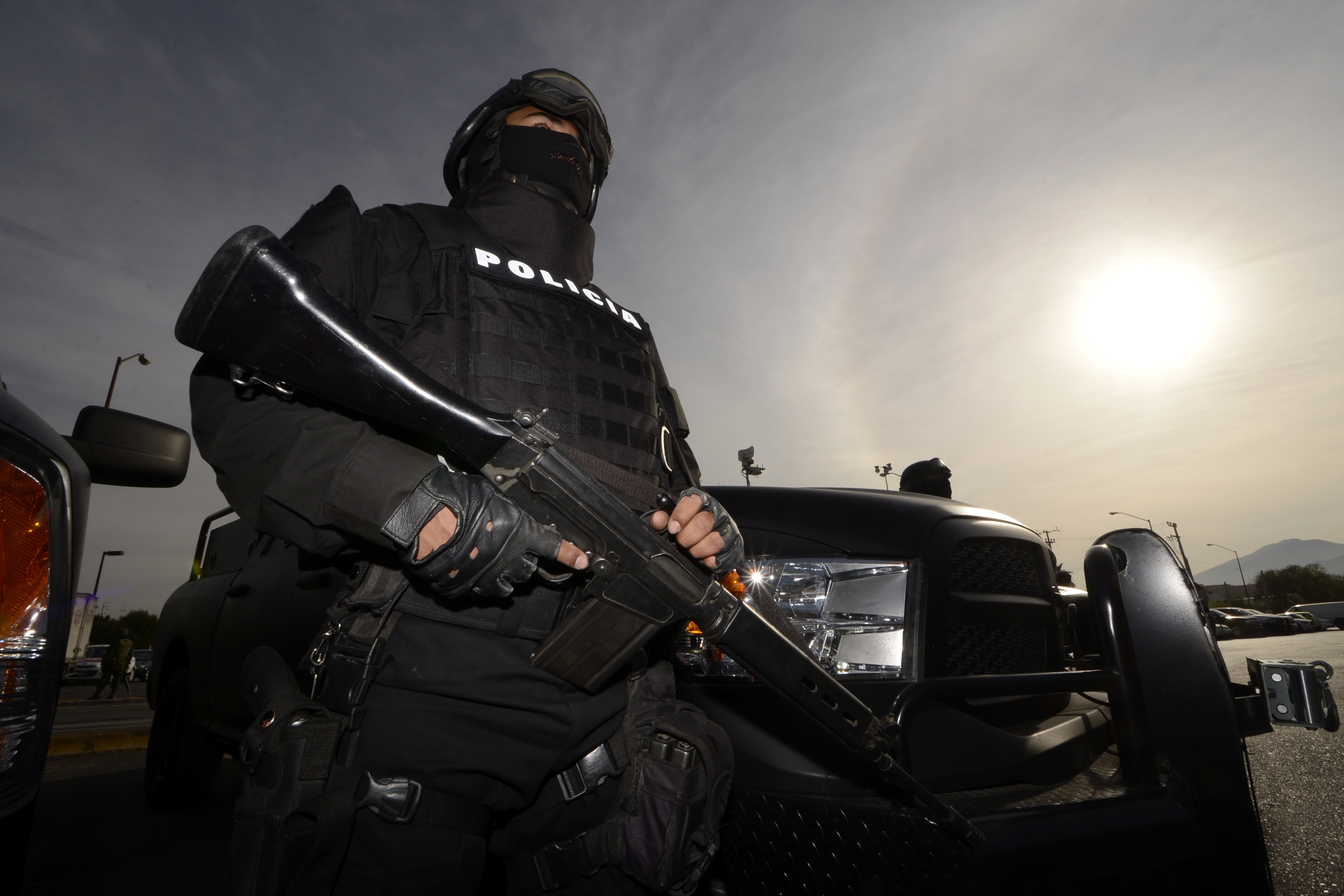 Police officer with rifle and tactical vehicle HD Wallpaper