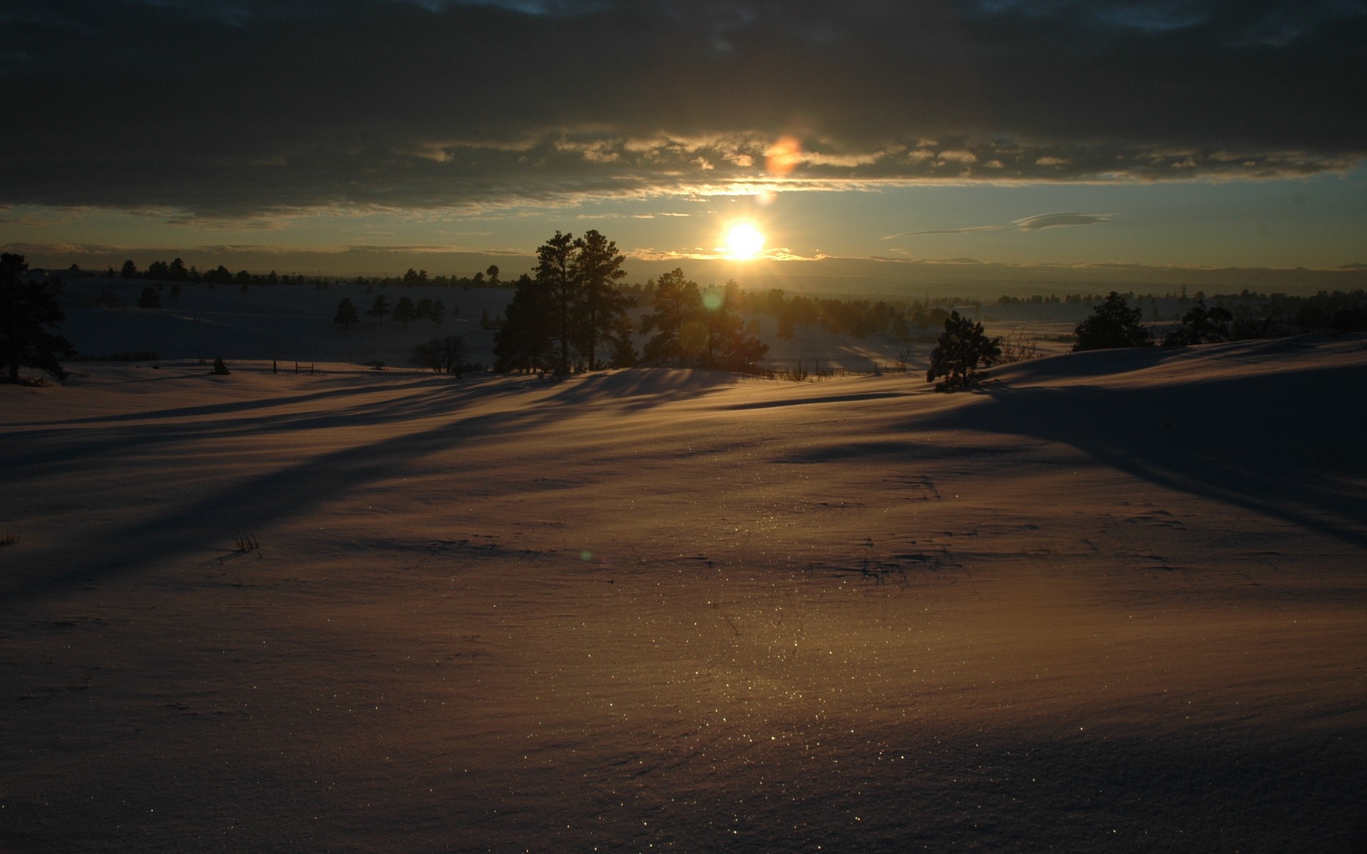 Snowy landscape at sunset with sunbeams HD Wallpaper