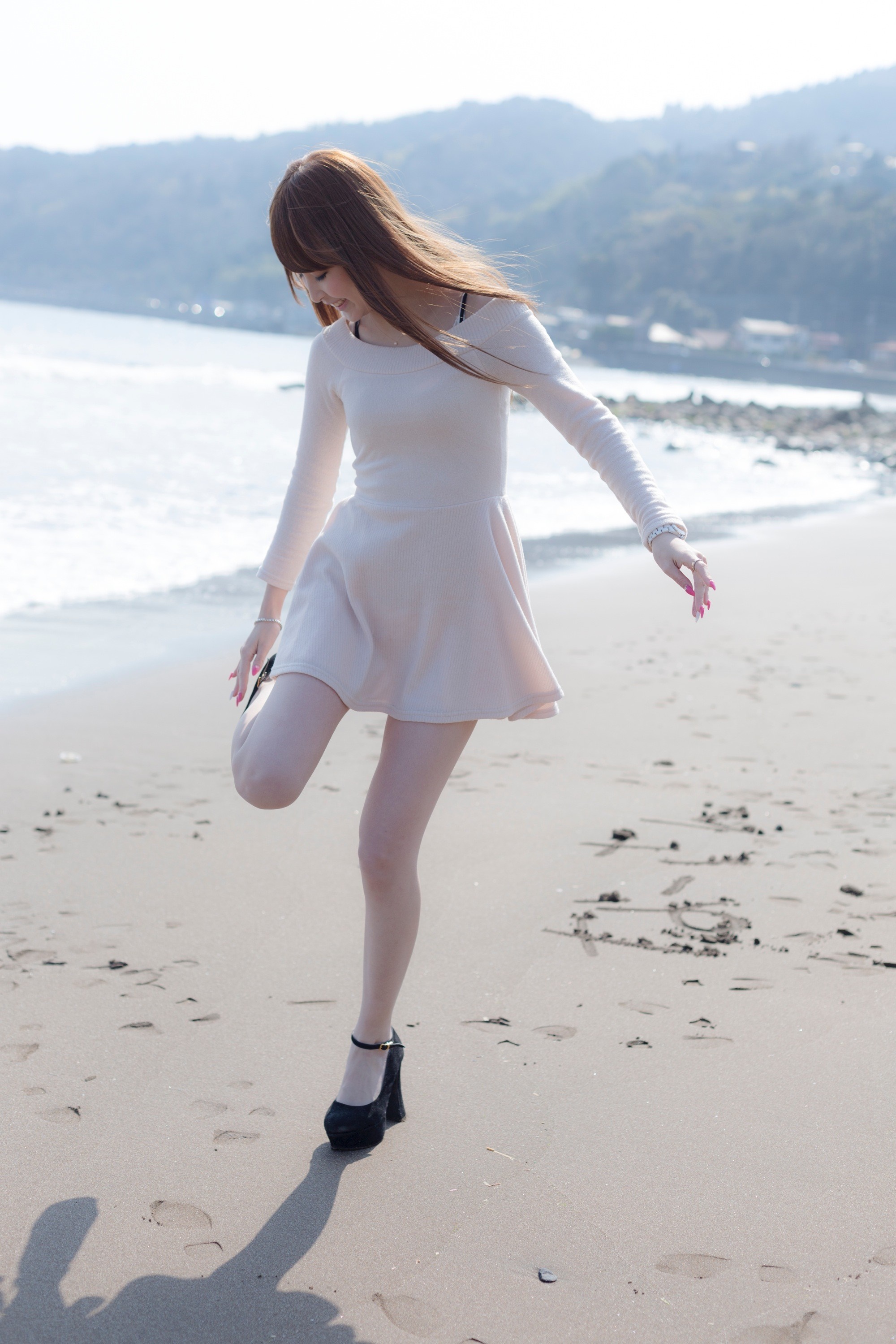 Asian woman in dress on beach stretching leg HD Wallpaper
