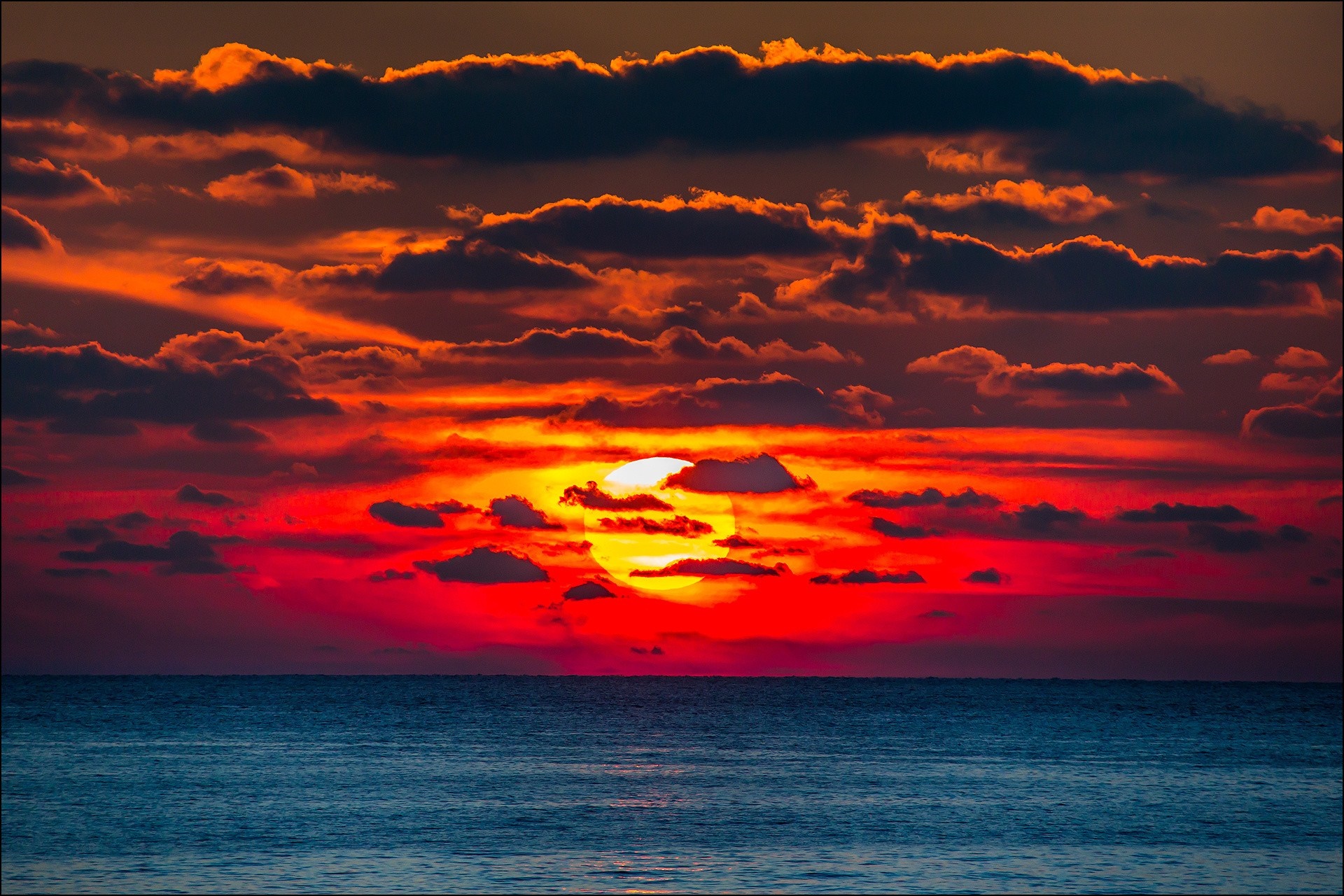 Sunset over the ocean with dramatic clouds HD Wallpaper