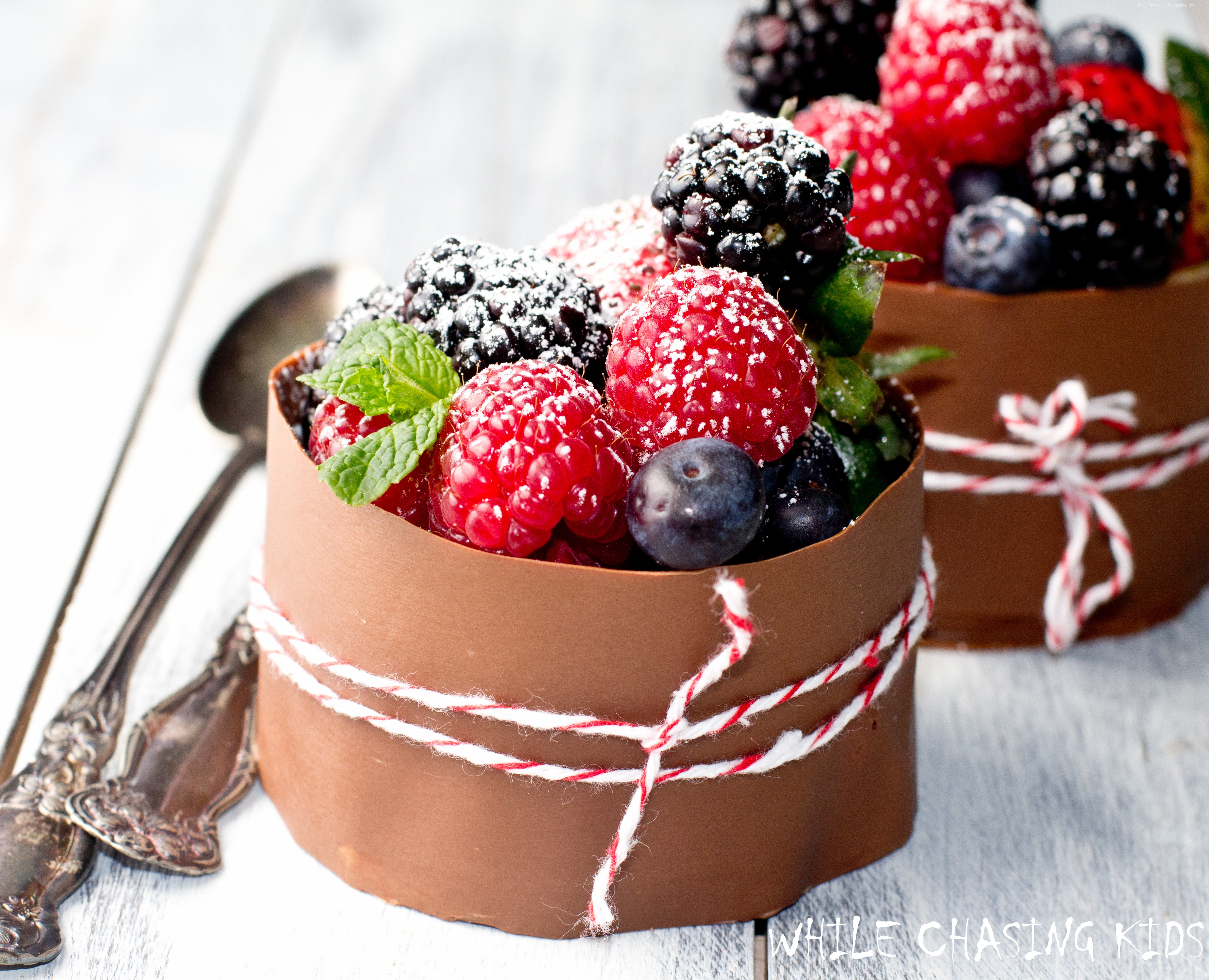 Chocolate cups filled with fresh berries and powdered sugar HD Wallpaper