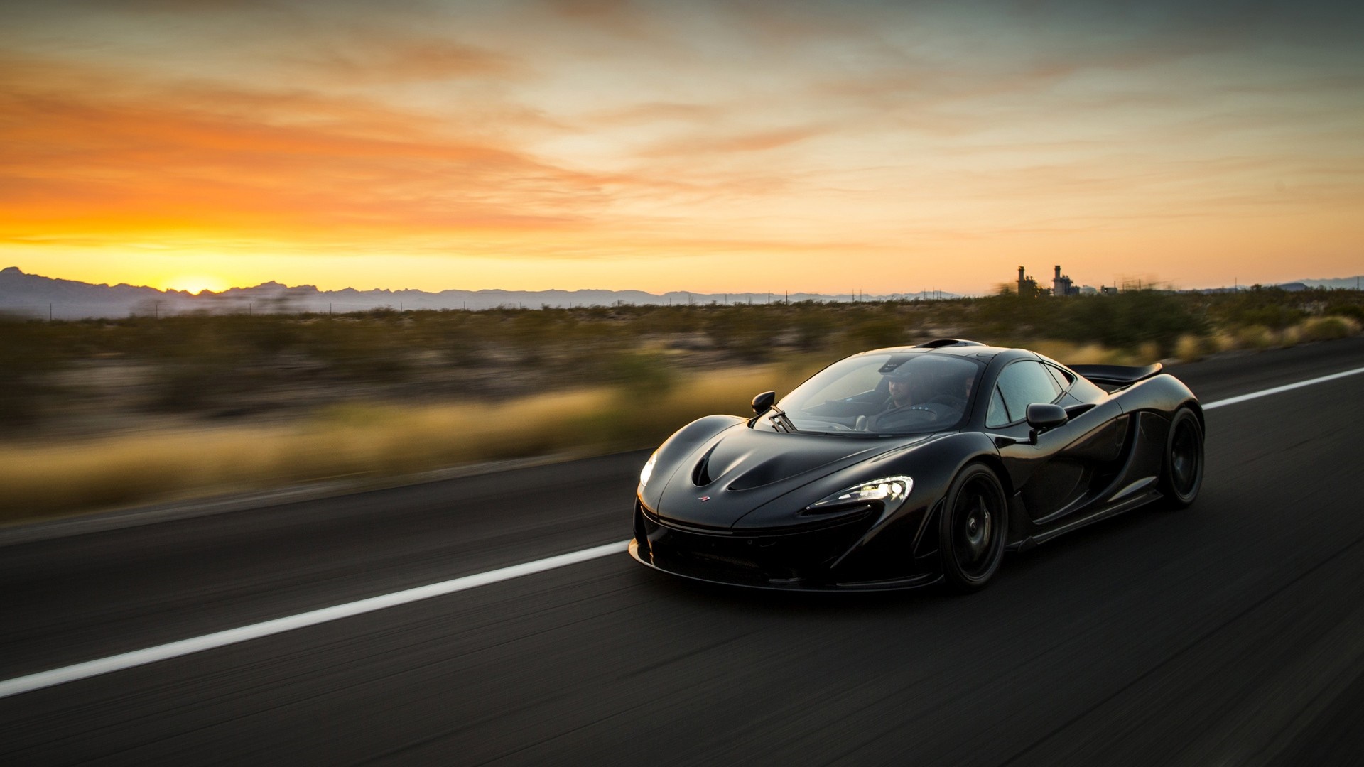 Black McLaren P1 driving on a desert road at sunset HD Wallpaper