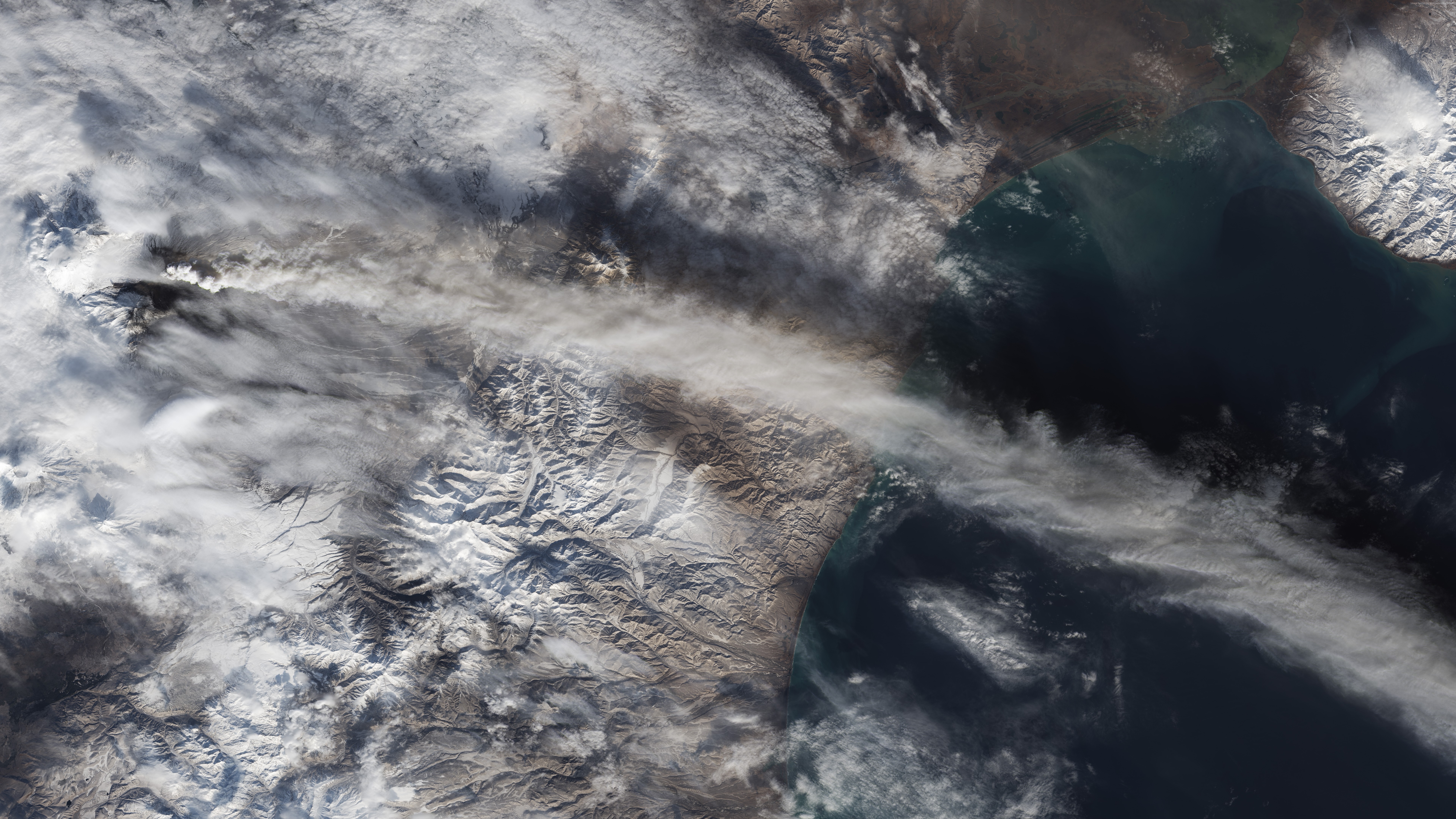 Satellite view of volcanic ash cloud over mountains and sea HD Wallpaper