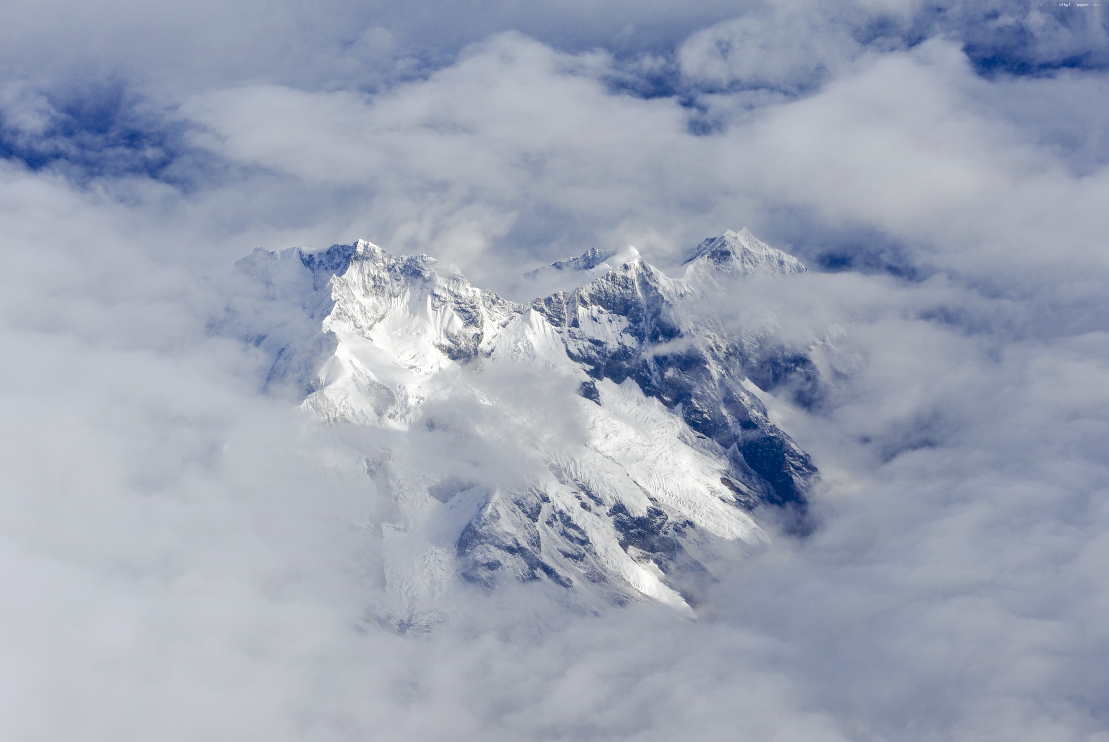 Snow-capped mountain peaks shrouded in clouds HD Wallpaper