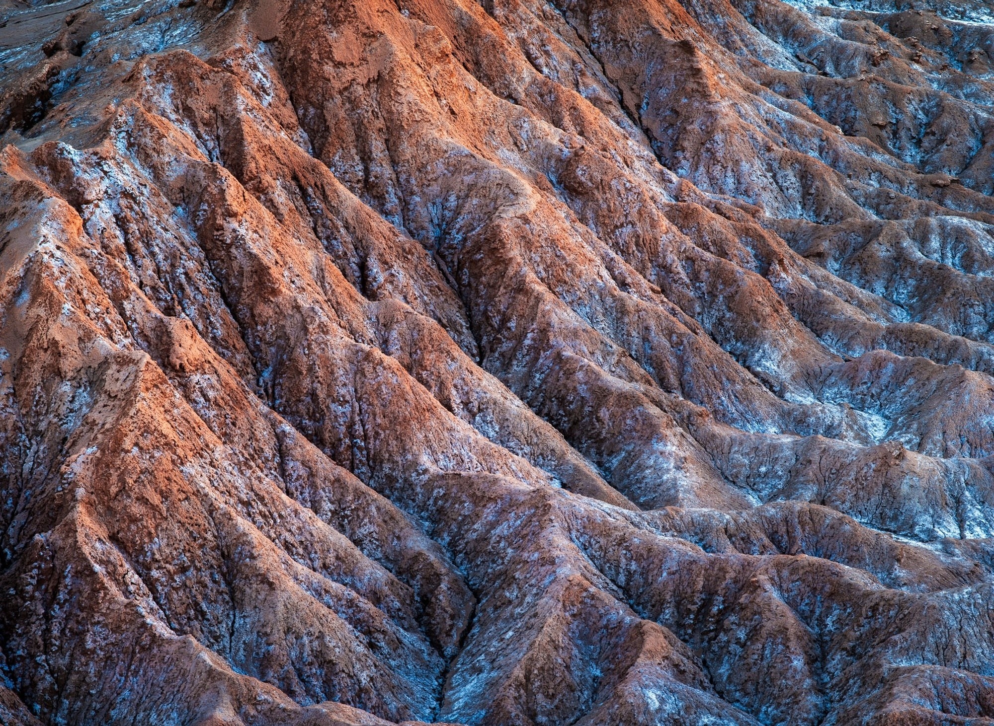 Textured desert landscape with eroded rock formations HD Wallpaper