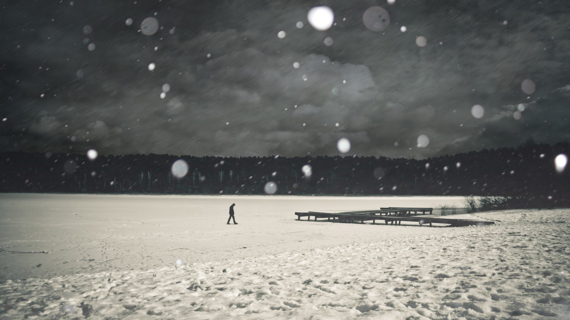 Person walking on a frozen lake during snowfall HD Wallpaper