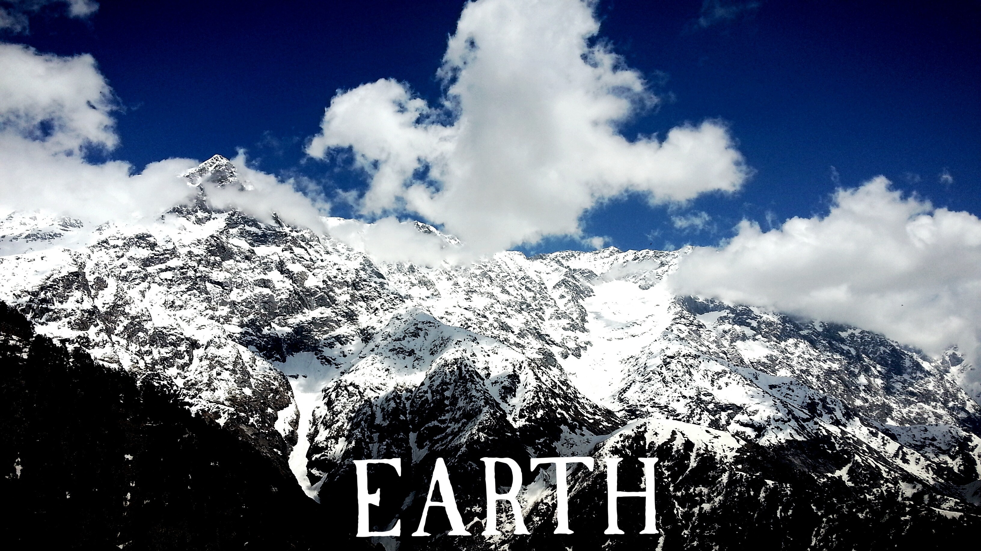 Snow-covered mountains under a blue sky with clouds HD Wallpaper
