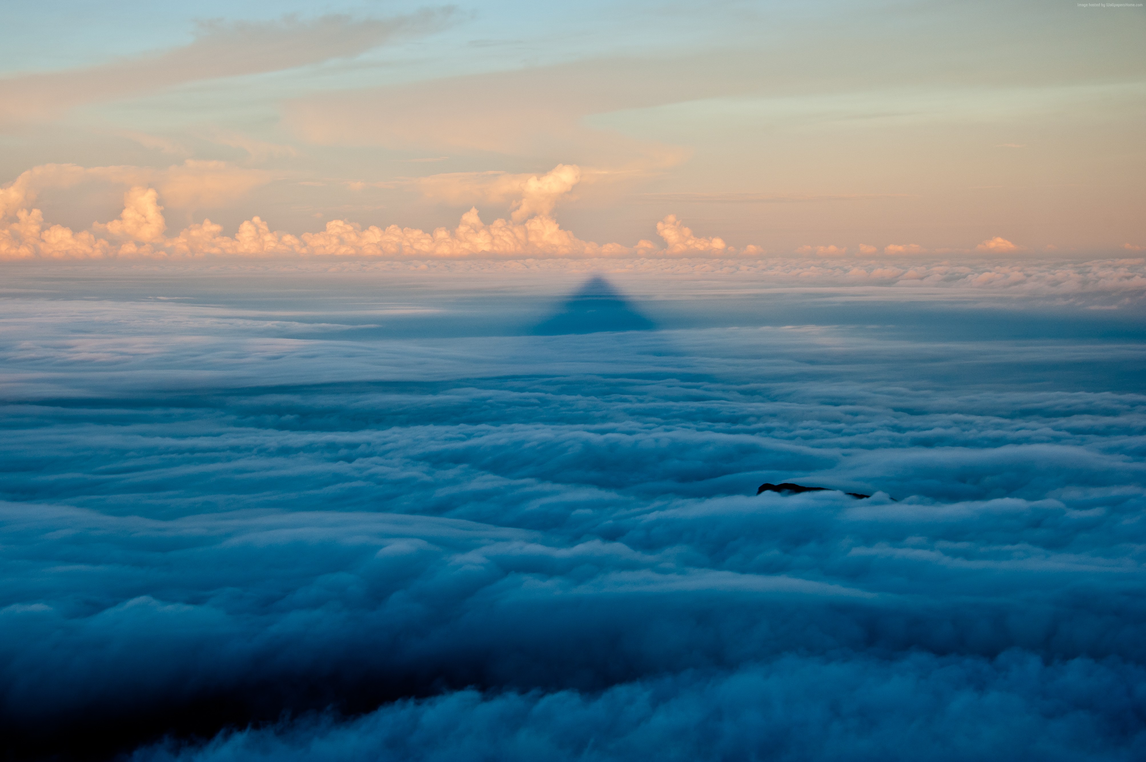 Shadow of a mountain over clouds at sunset HD Wallpaper