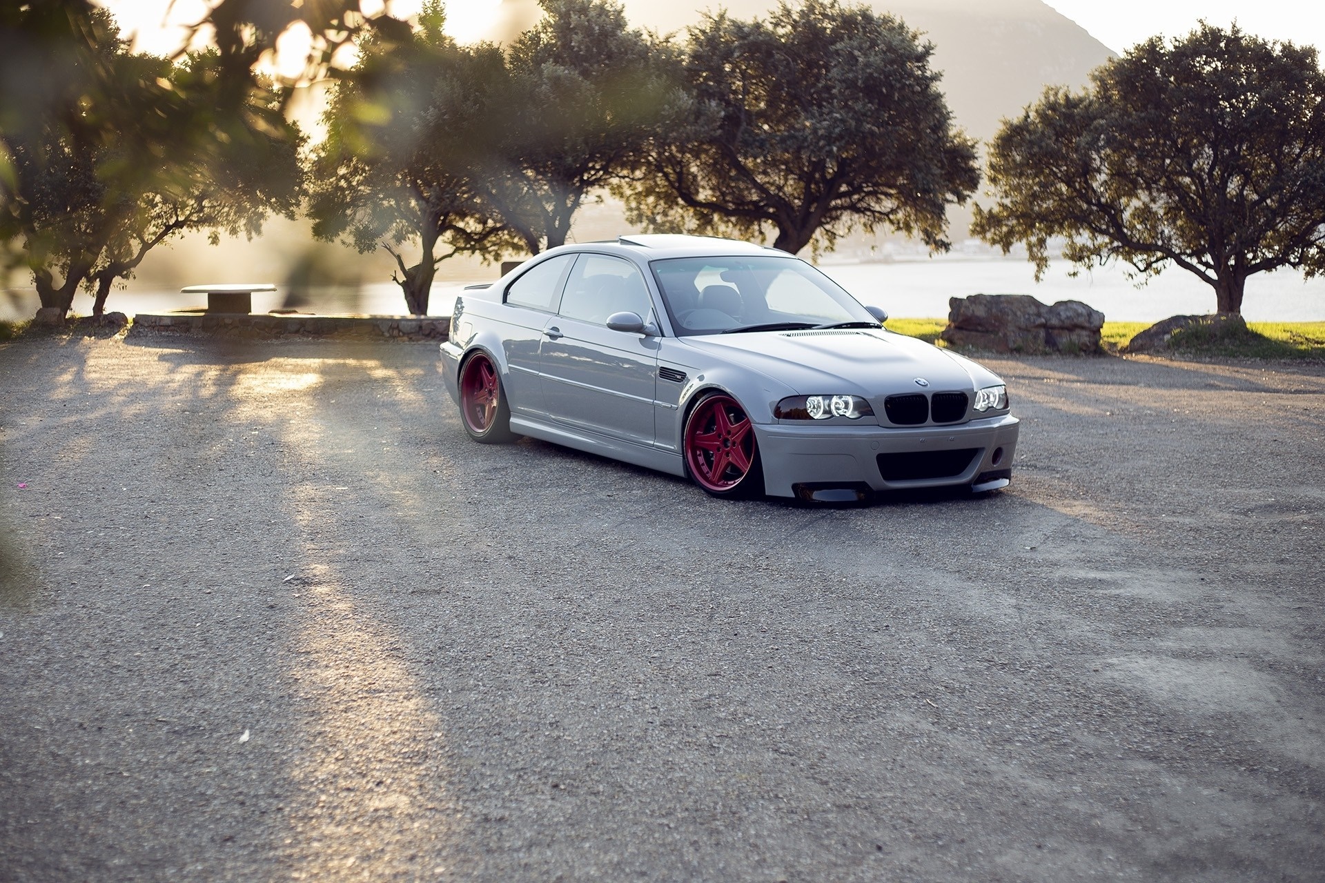 Gray BMW M3 with red wheels parked by a lake HD Wallpaper