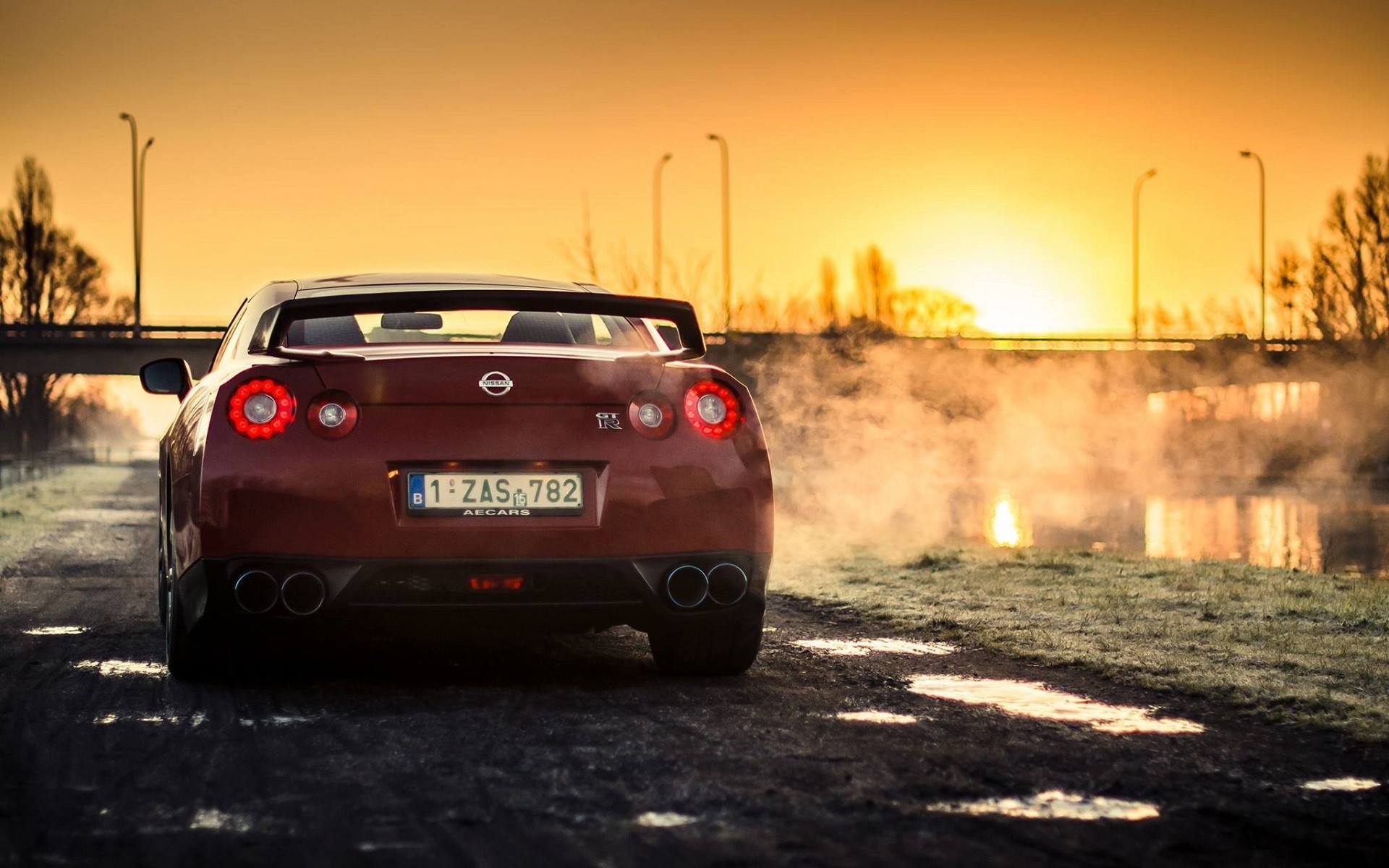 Red Nissan GT-R sports car at sunset with smoke HD Wallpaper