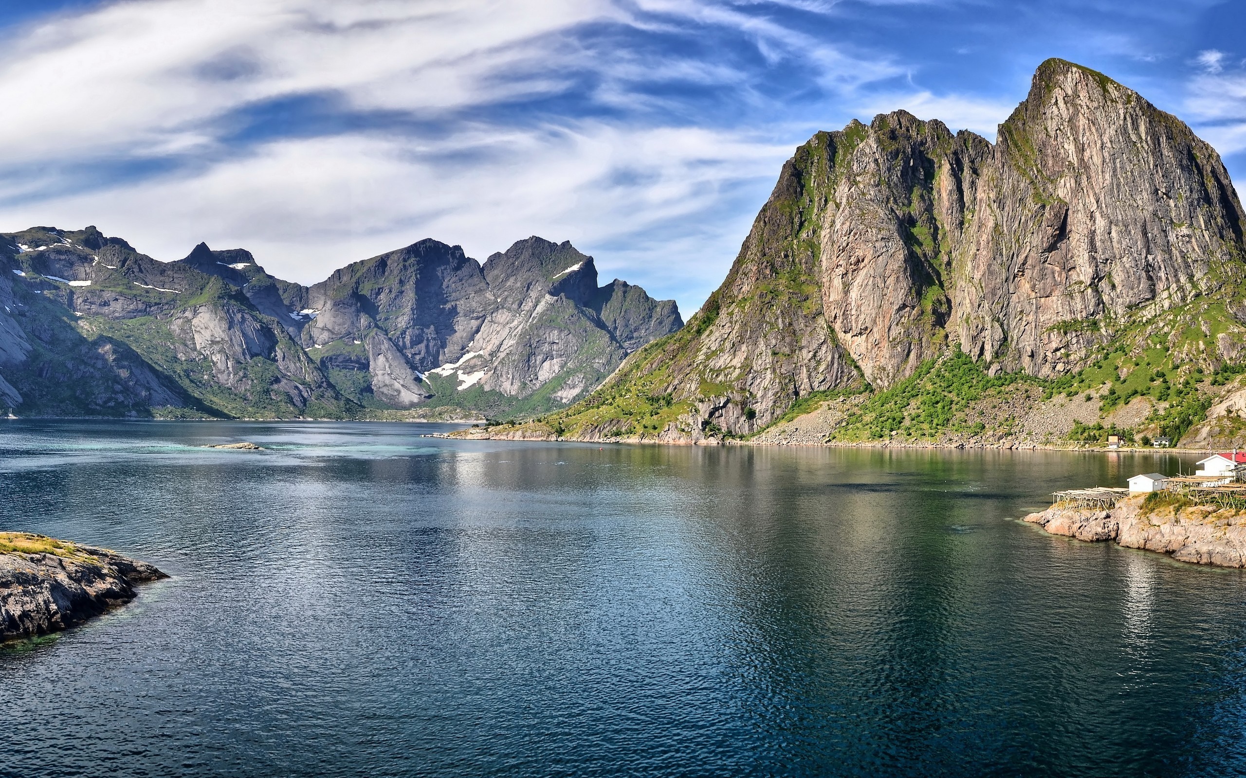 Majestic mountains reflected in a calm fjord under a cloudy sky HD Wallpaper