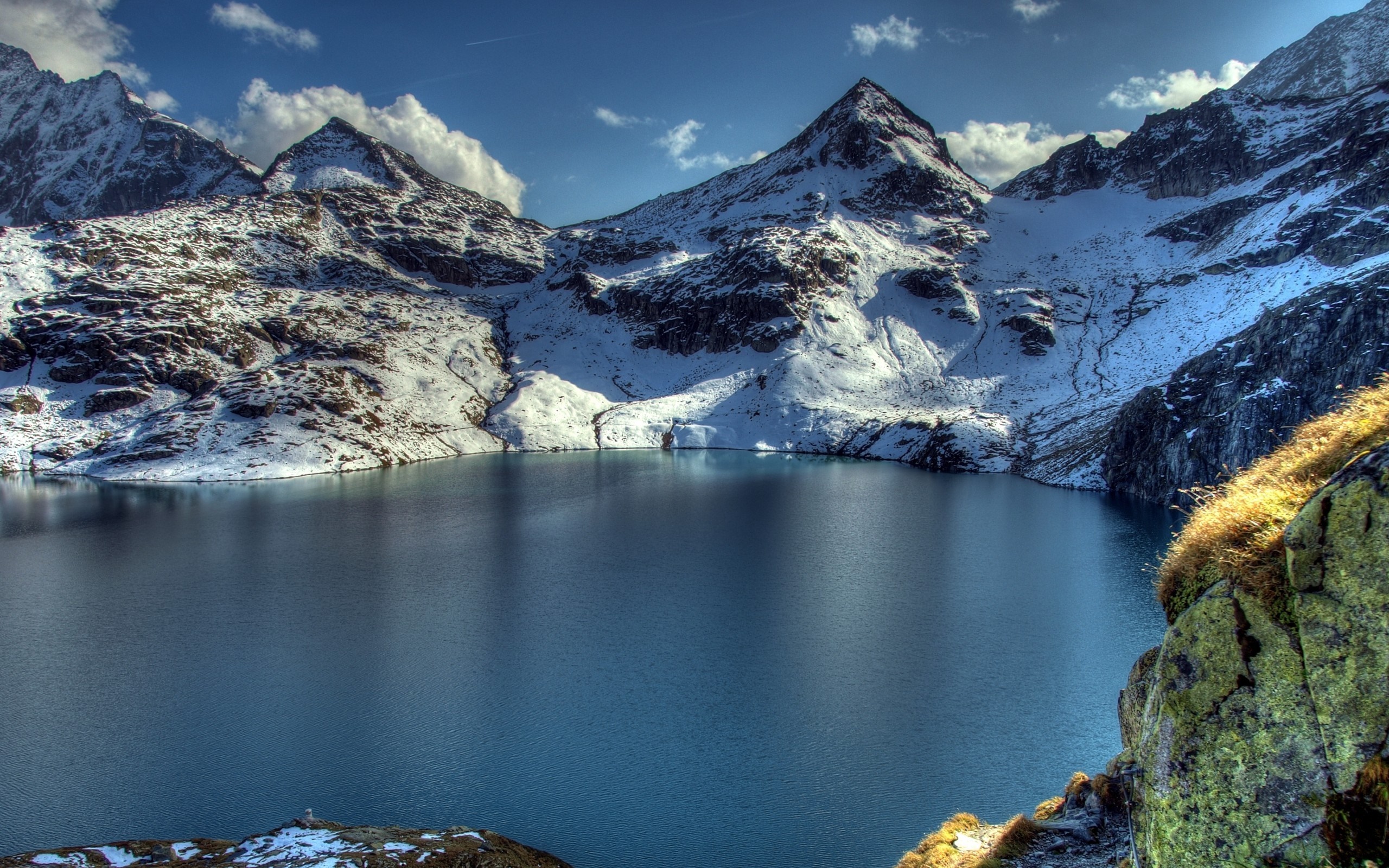Snow-covered mountains surrounding a blue lake HD Wallpaper