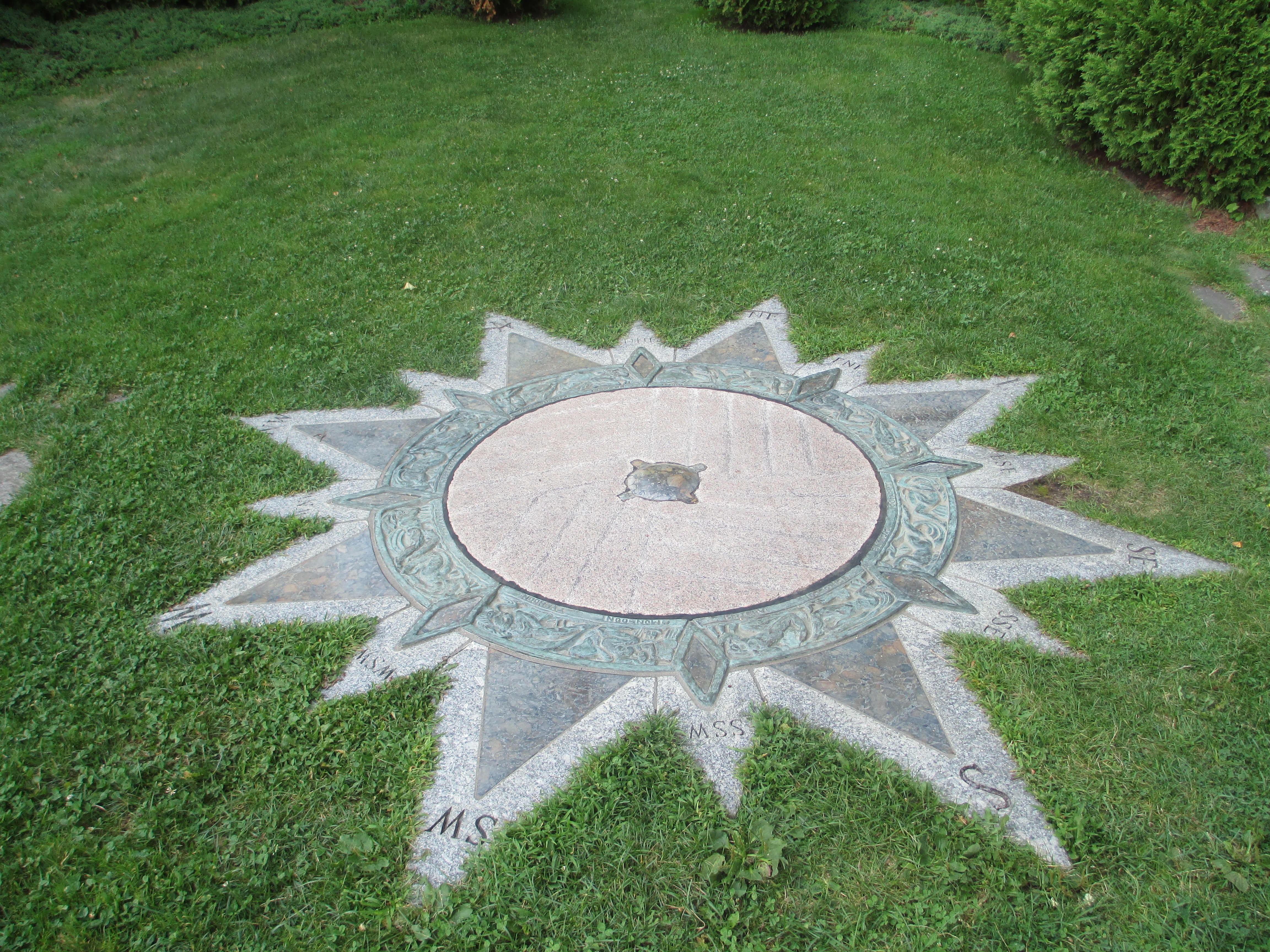 Compass rose garden feature on a lawn HD Wallpaper
