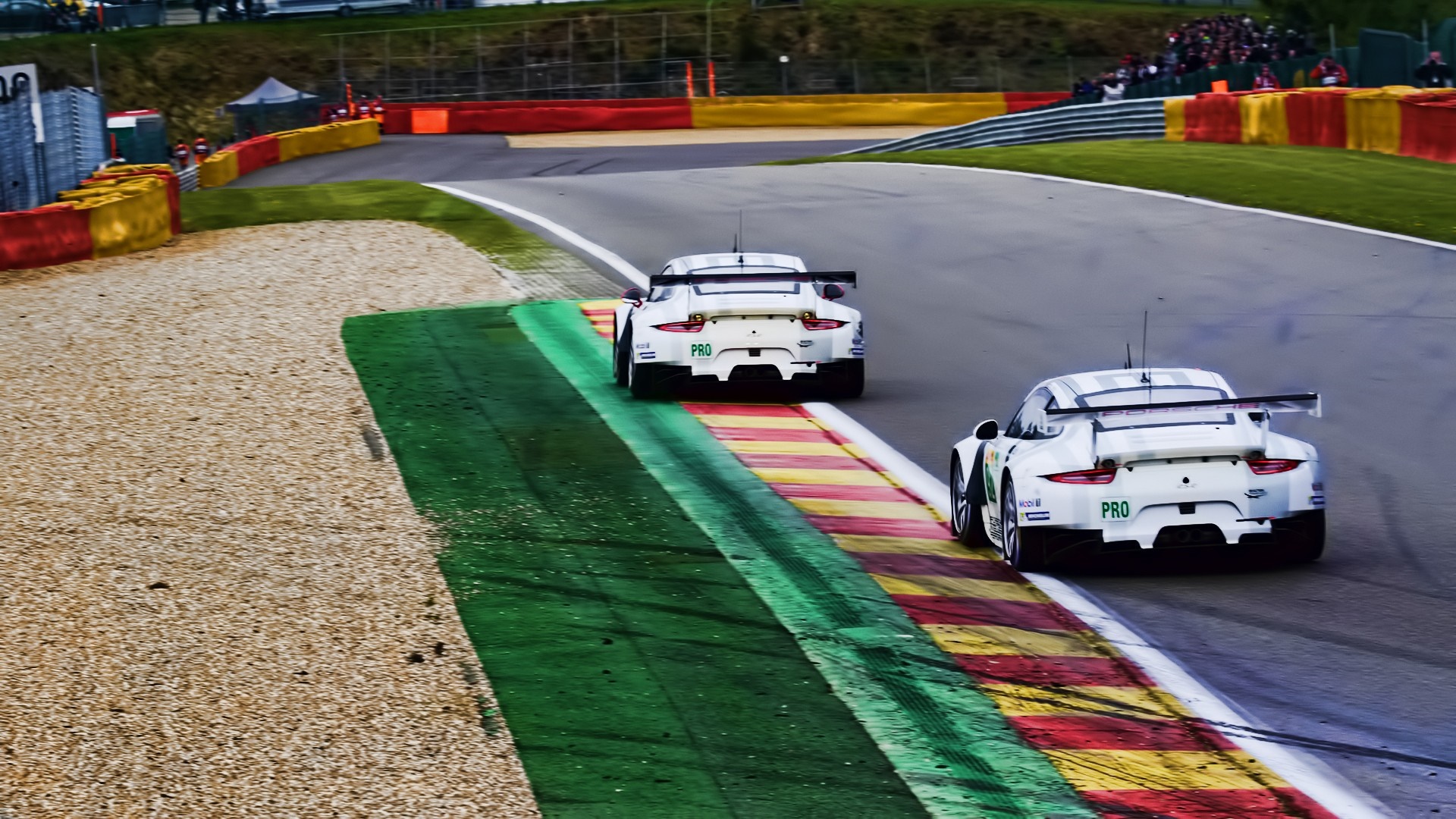 Two Porsche 911 race cars on a race track HD Wallpaper