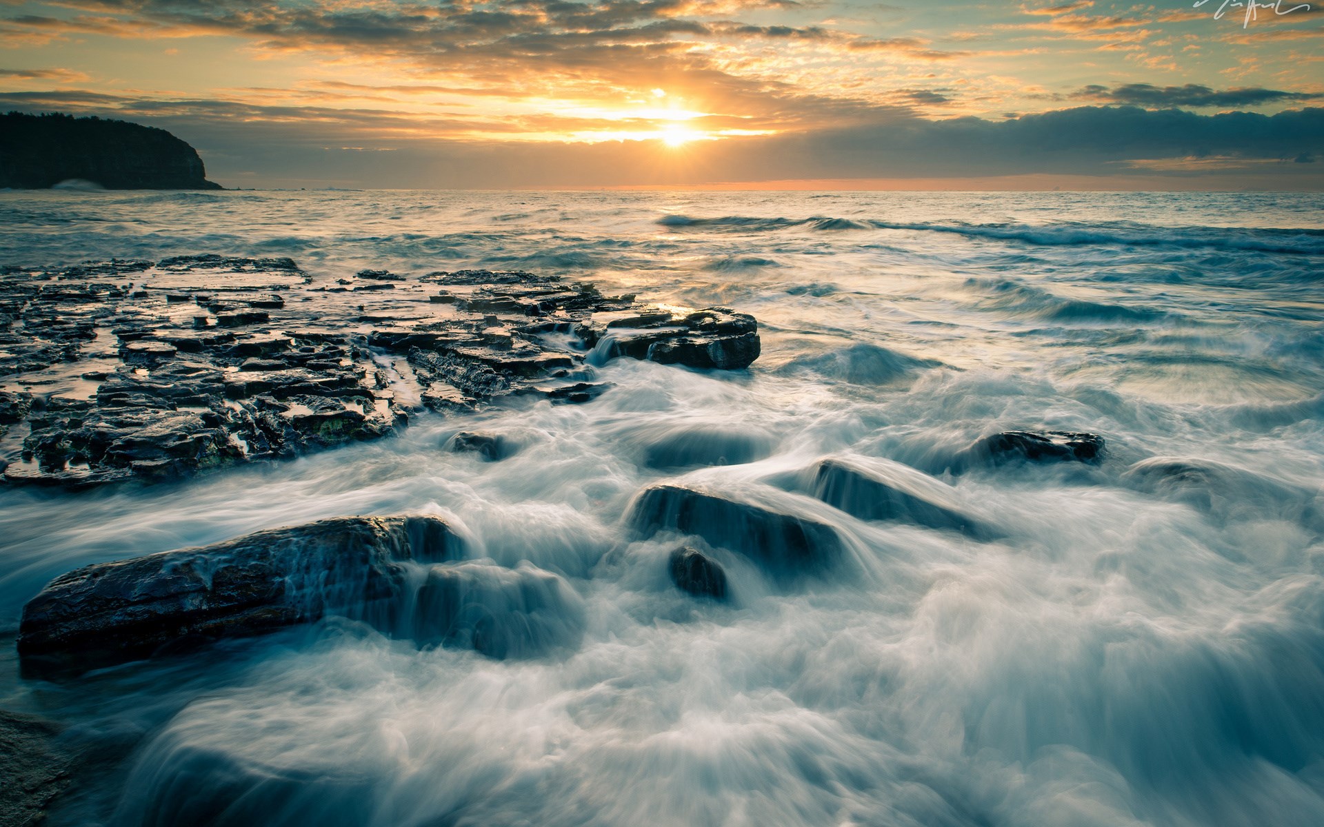 Ocean waves crashing on rocky shore at sunset HD Wallpaper