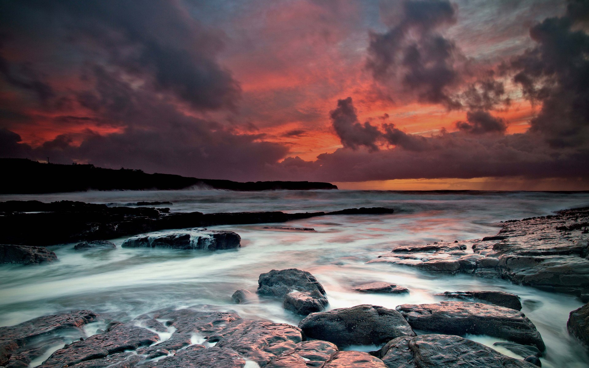 Rocky coastline at sunset with dramatic clouds HD Wallpaper