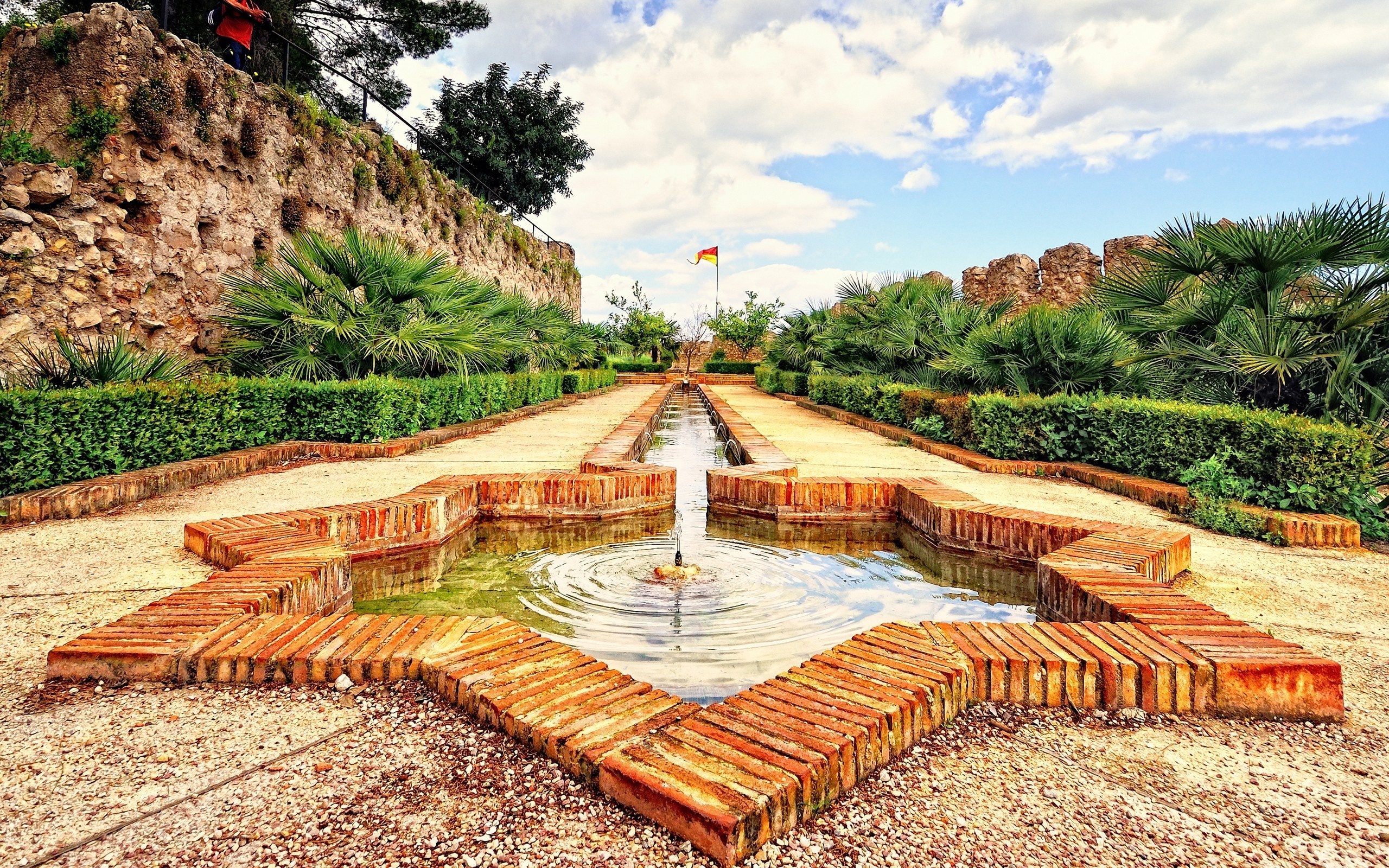 Garden with star-shaped fountain and stone wall HD Wallpaper