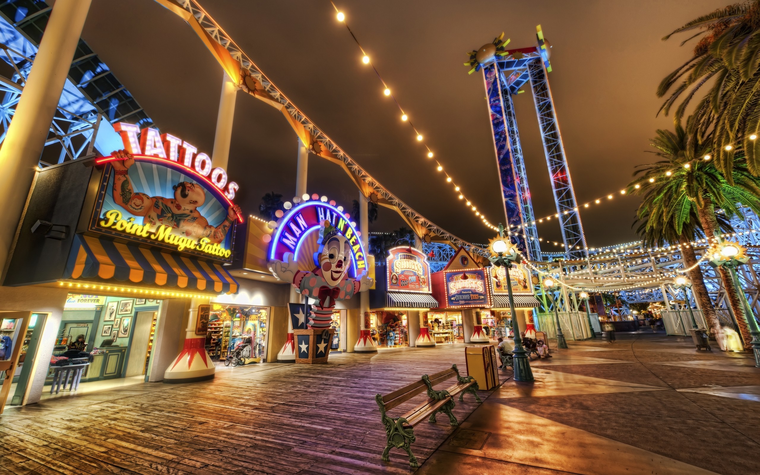 Amusement park at night with rides and shops HD Wallpaper