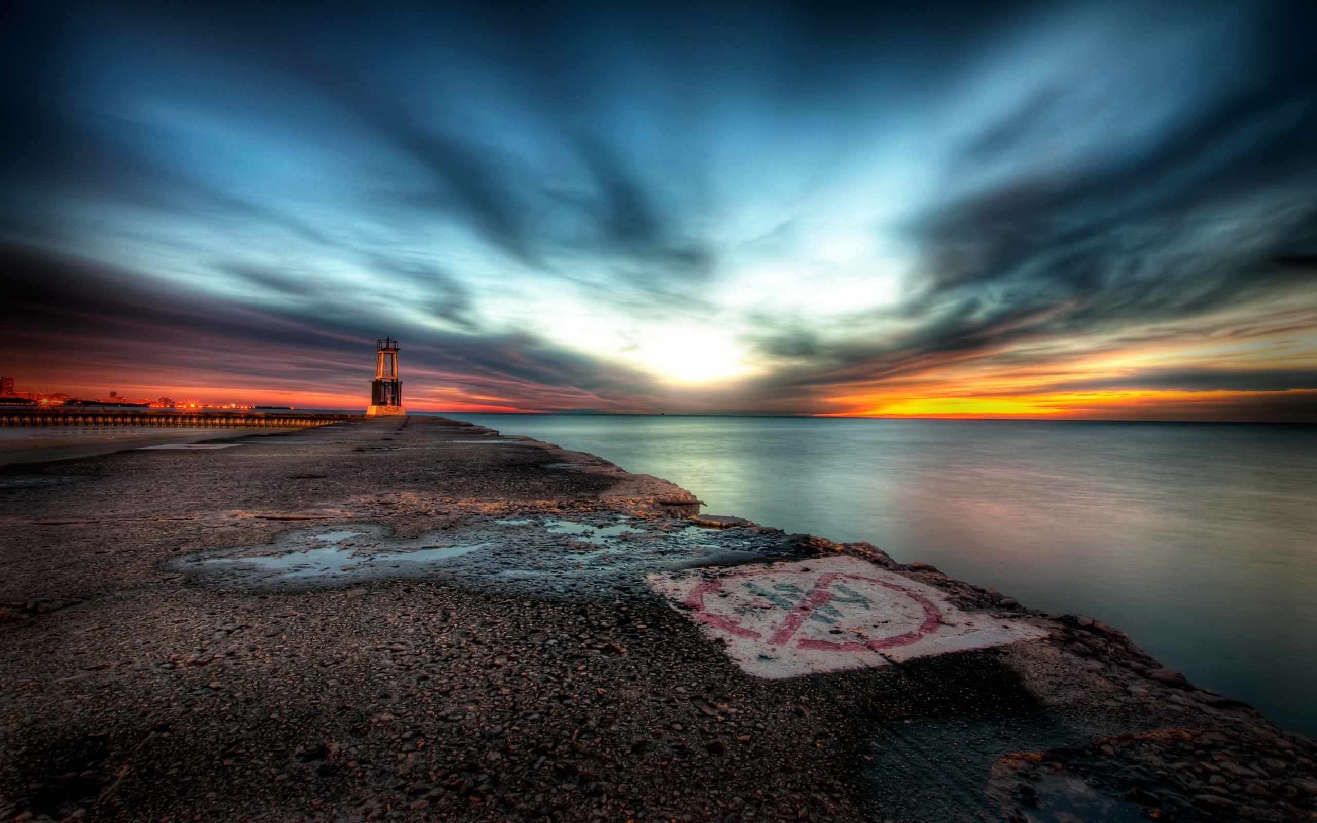 Sunset over the ocean with a lighthouse on a pier HD Wallpaper