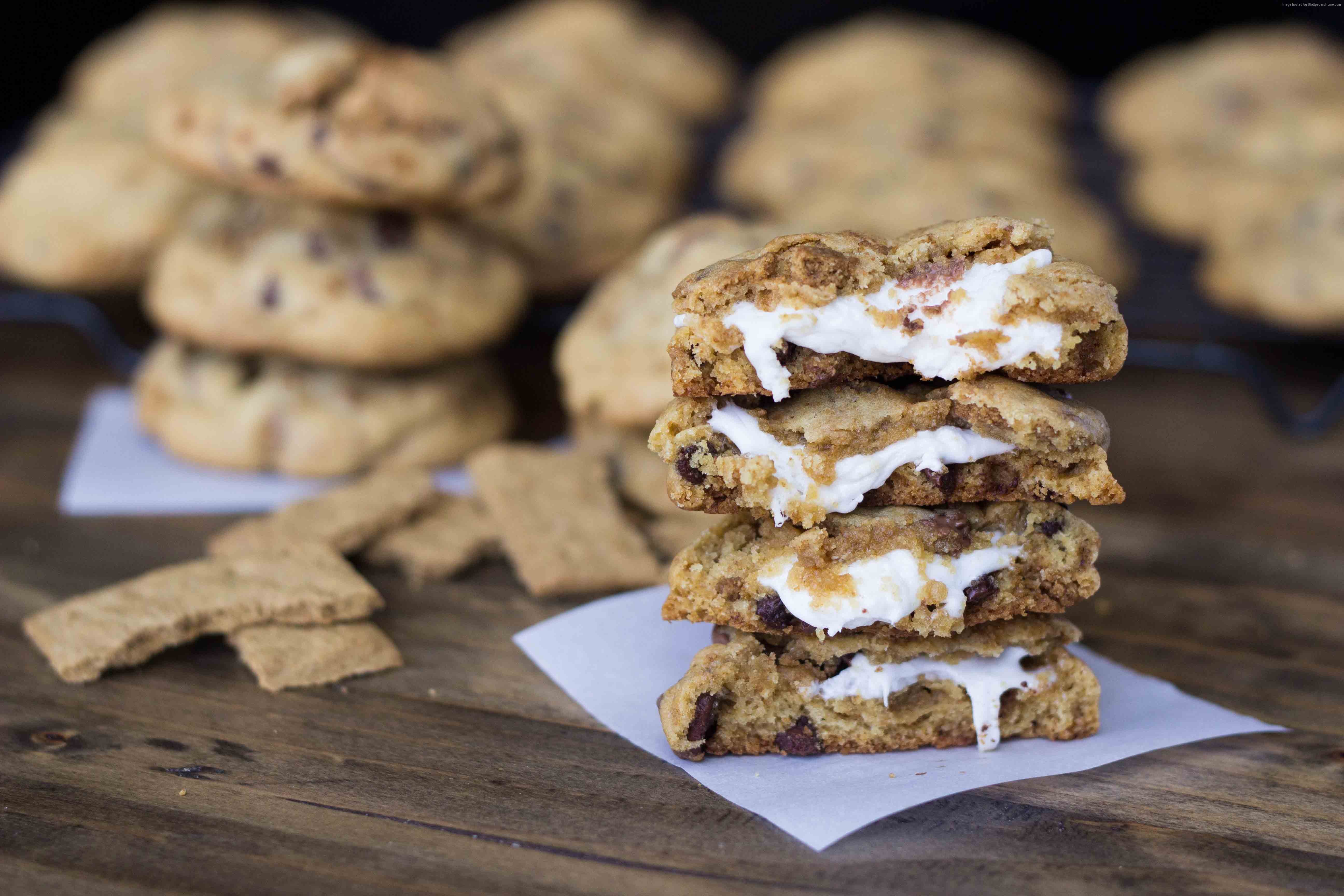 S'mores stuffed chocolate chip cookies stacked on a wooden table HD Wallpaper