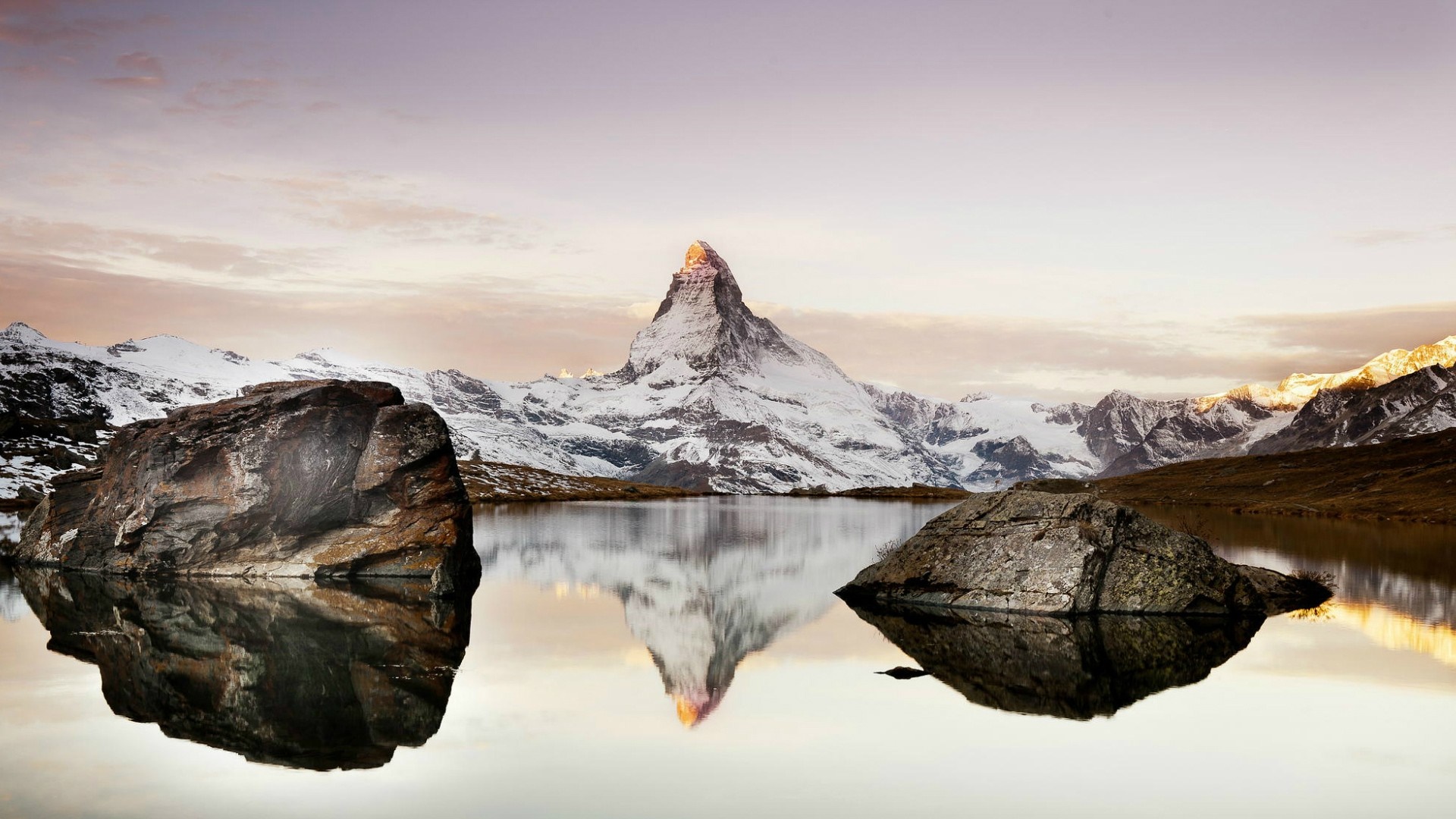 Matterhorn mountain reflected in a lake with rocks HD Wallpaper