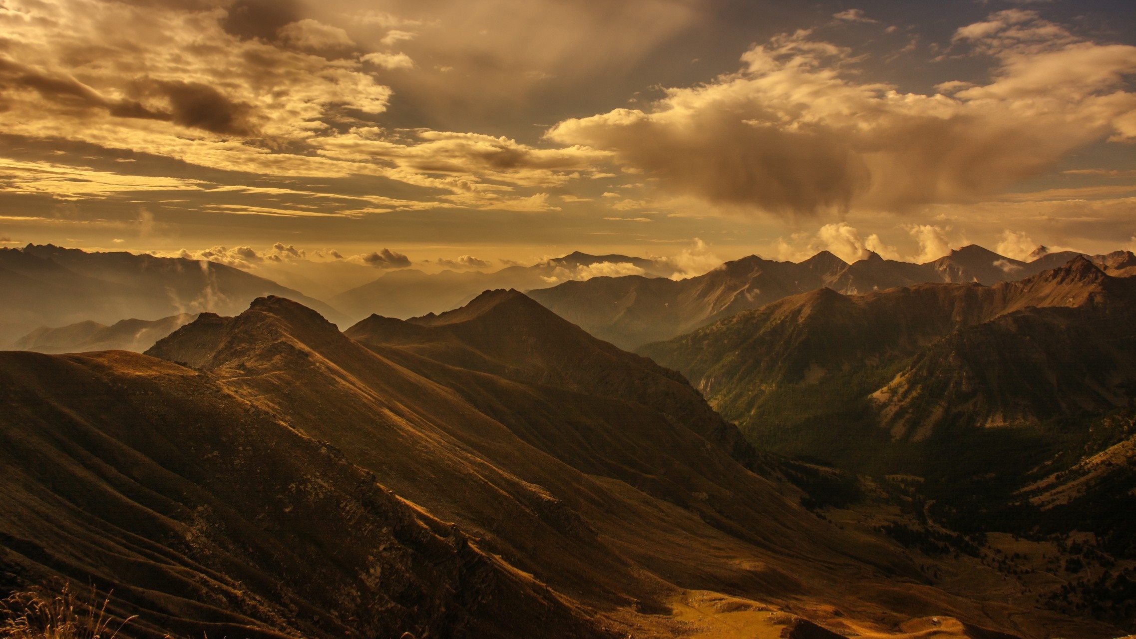 Mountain range at sunset with dramatic clouds HD Wallpaper