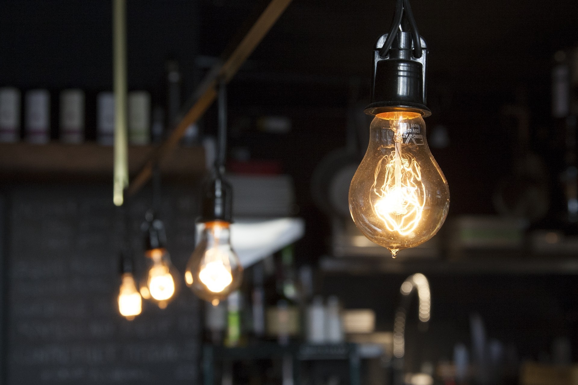 Incandescent light bulbs hanging in a dimly lit interior HD Wallpaper