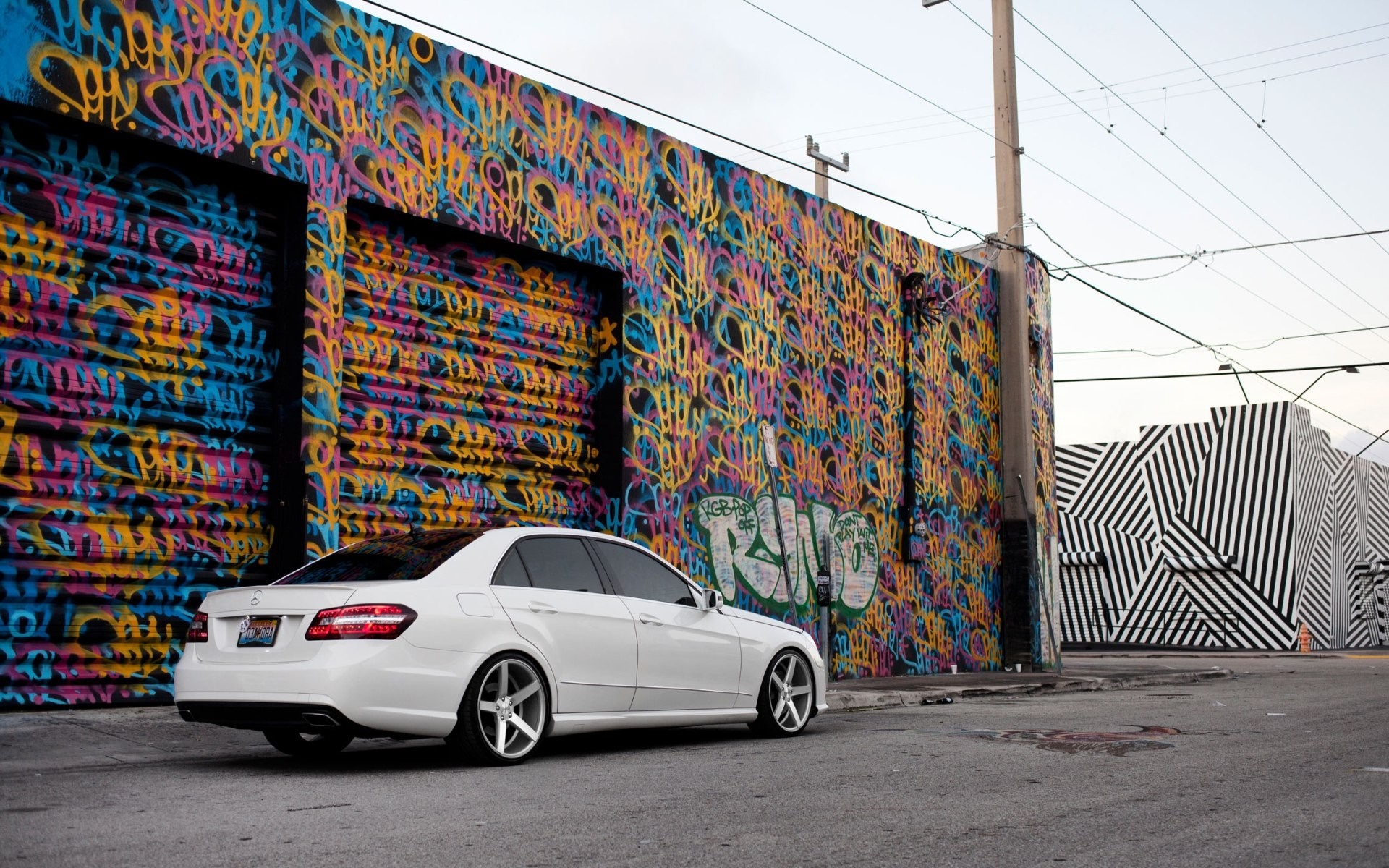 White Mercedes-Benz E-Class parked by graffiti wall HD Wallpaper