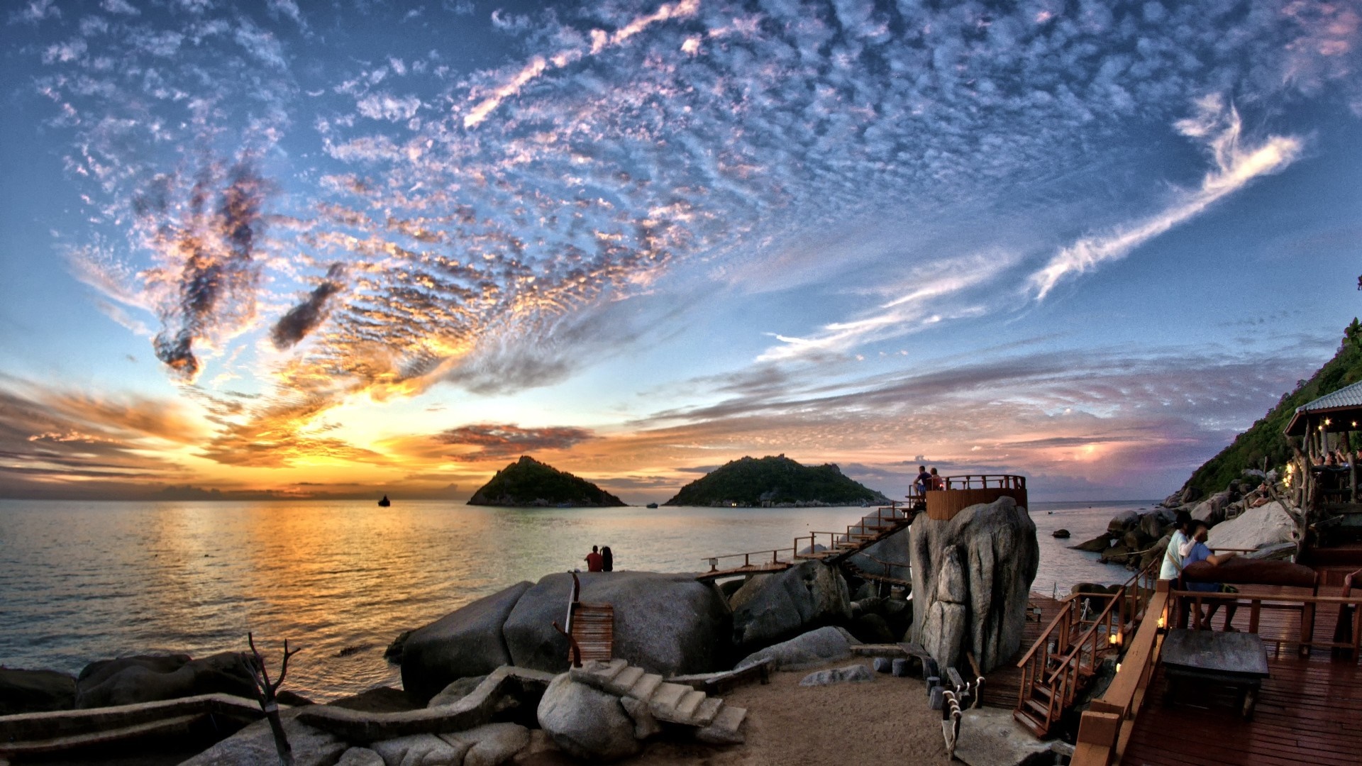 Sunset over the ocean with islands and a wooden deck HD Wallpaper