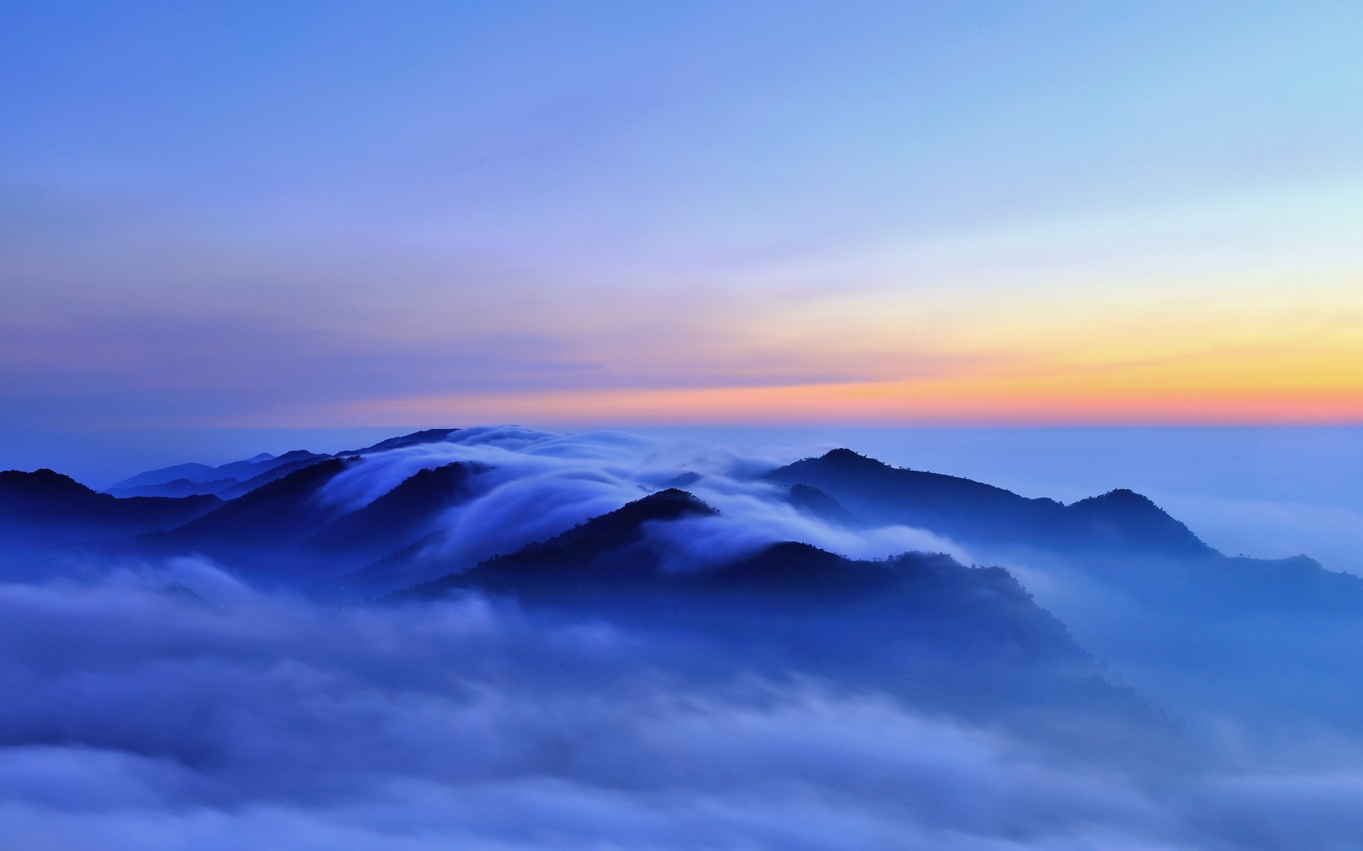 Mountains shrouded in mist at sunrise HD Wallpaper