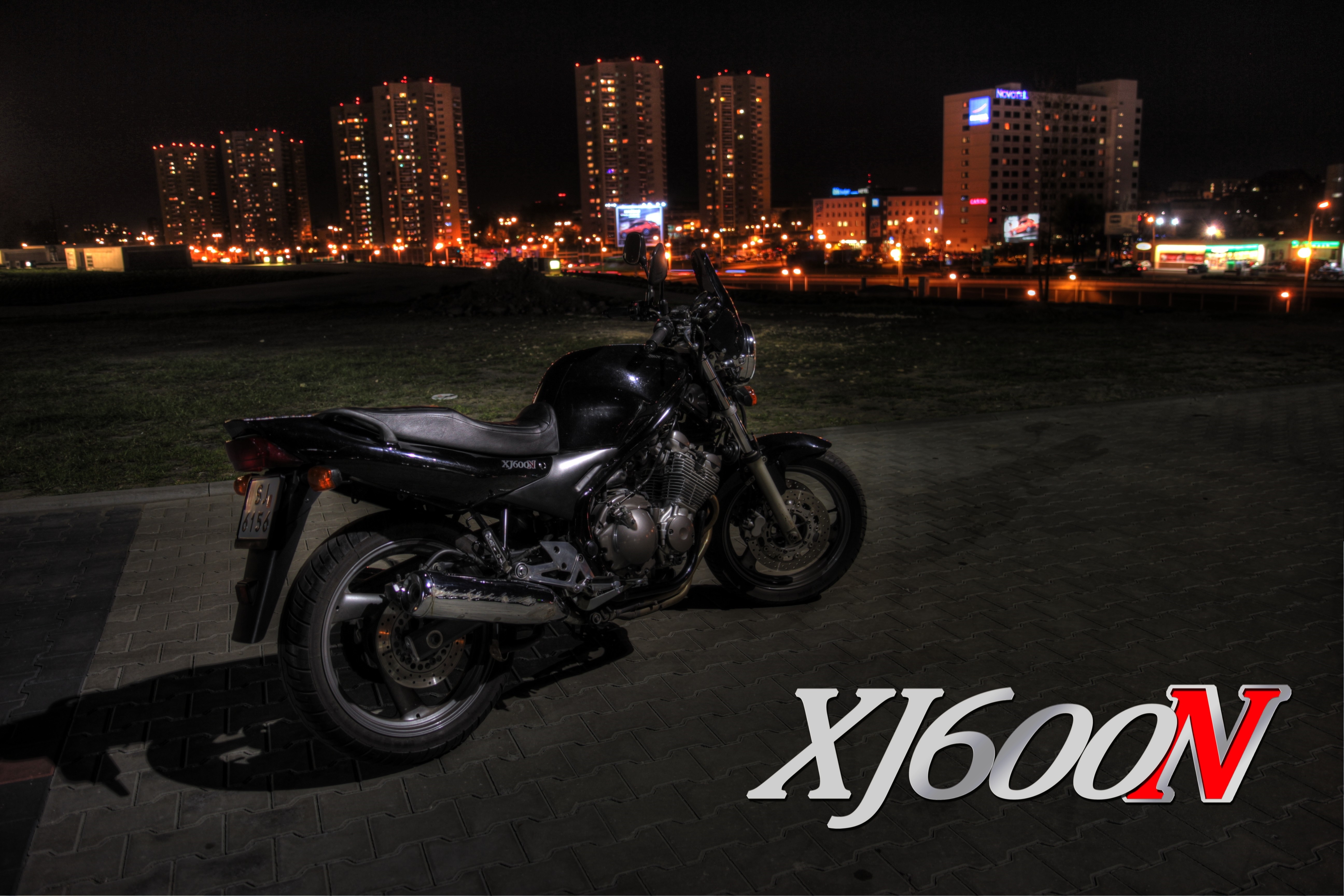 Yamaha XJ600N motorcycle parked at night with city skyline HD Wallpaper