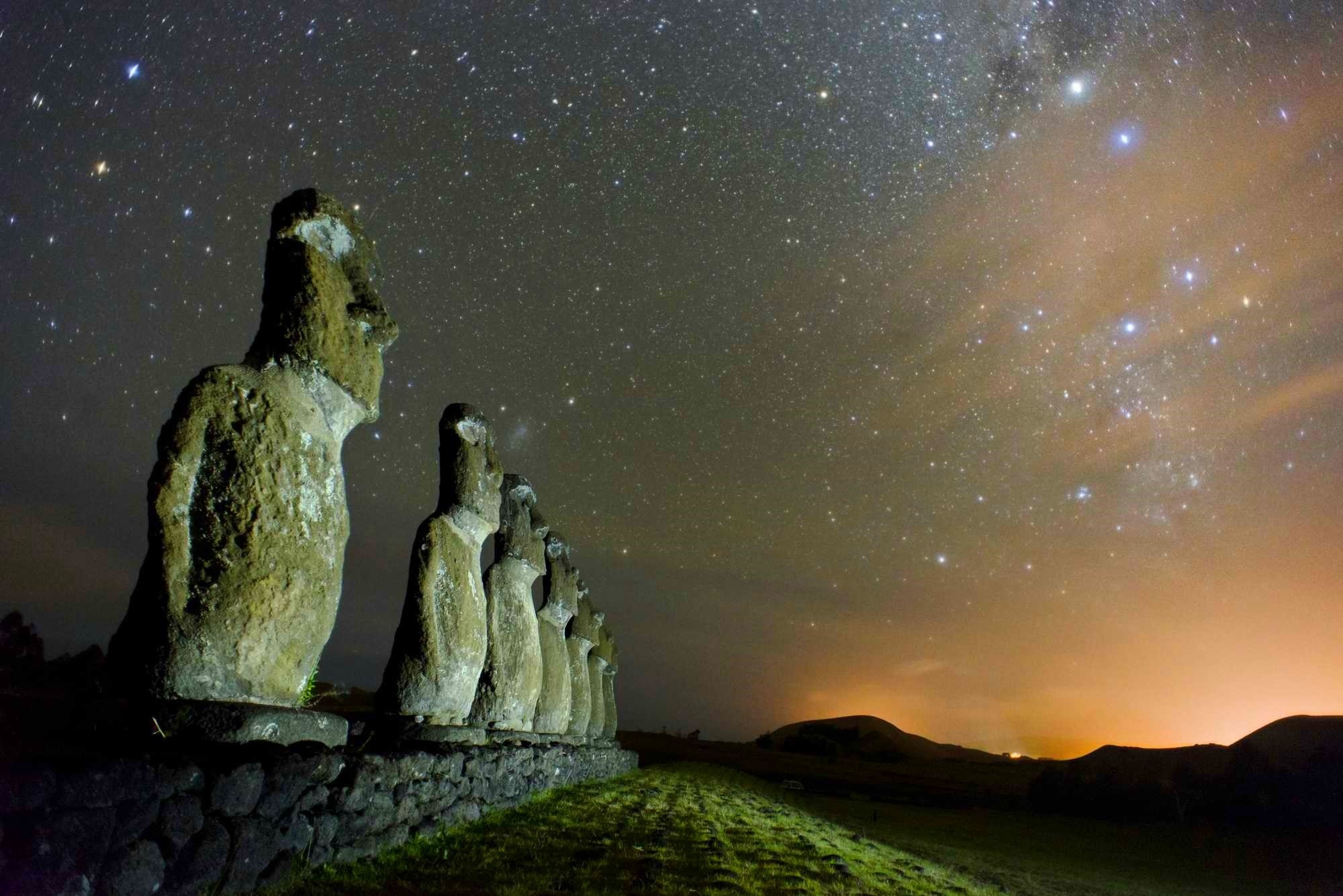 Moai statues under a starry night sky on Easter Island HD Wallpaper