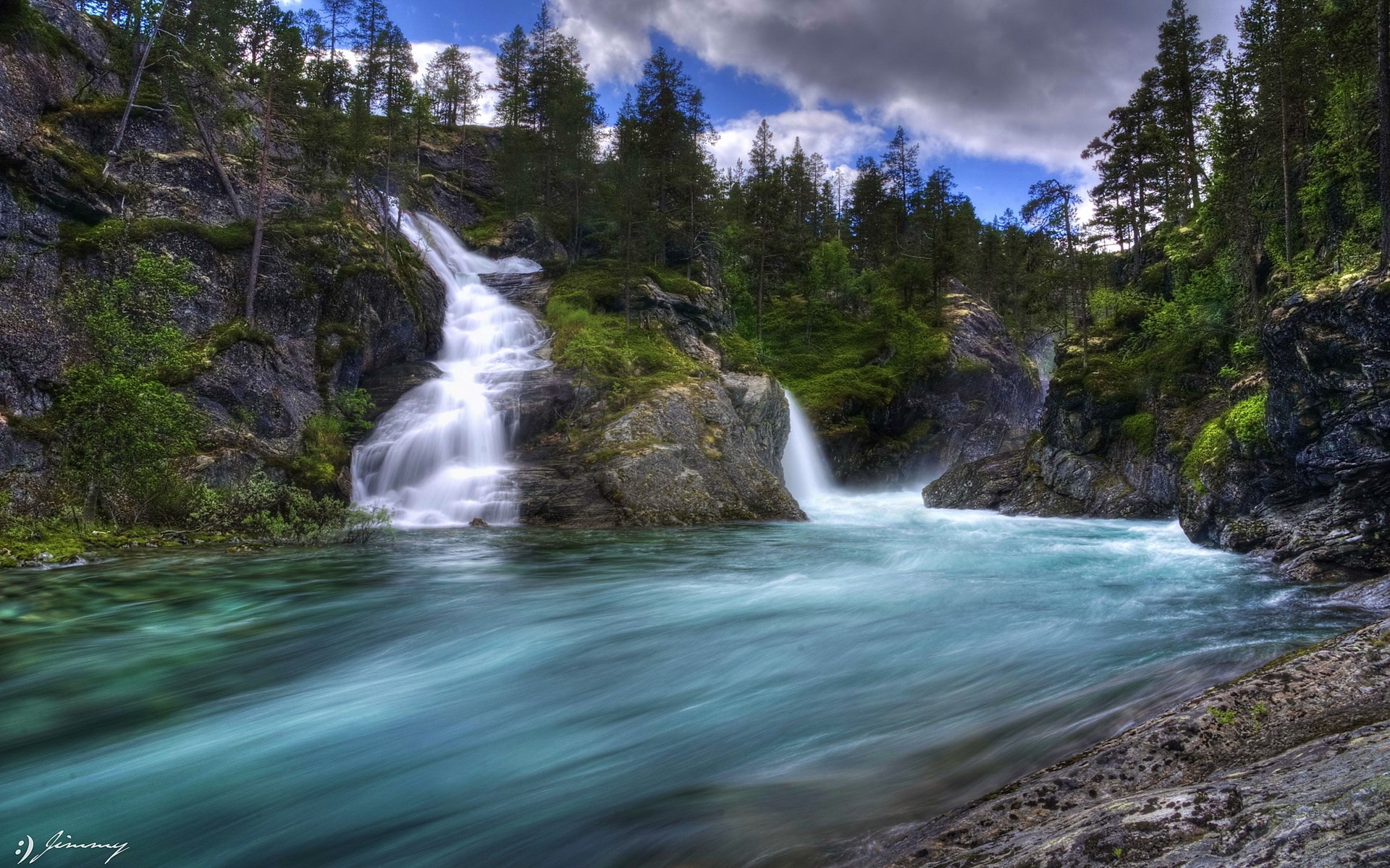 Waterfall flowing into a turquoise river in a forest HD Wallpaper