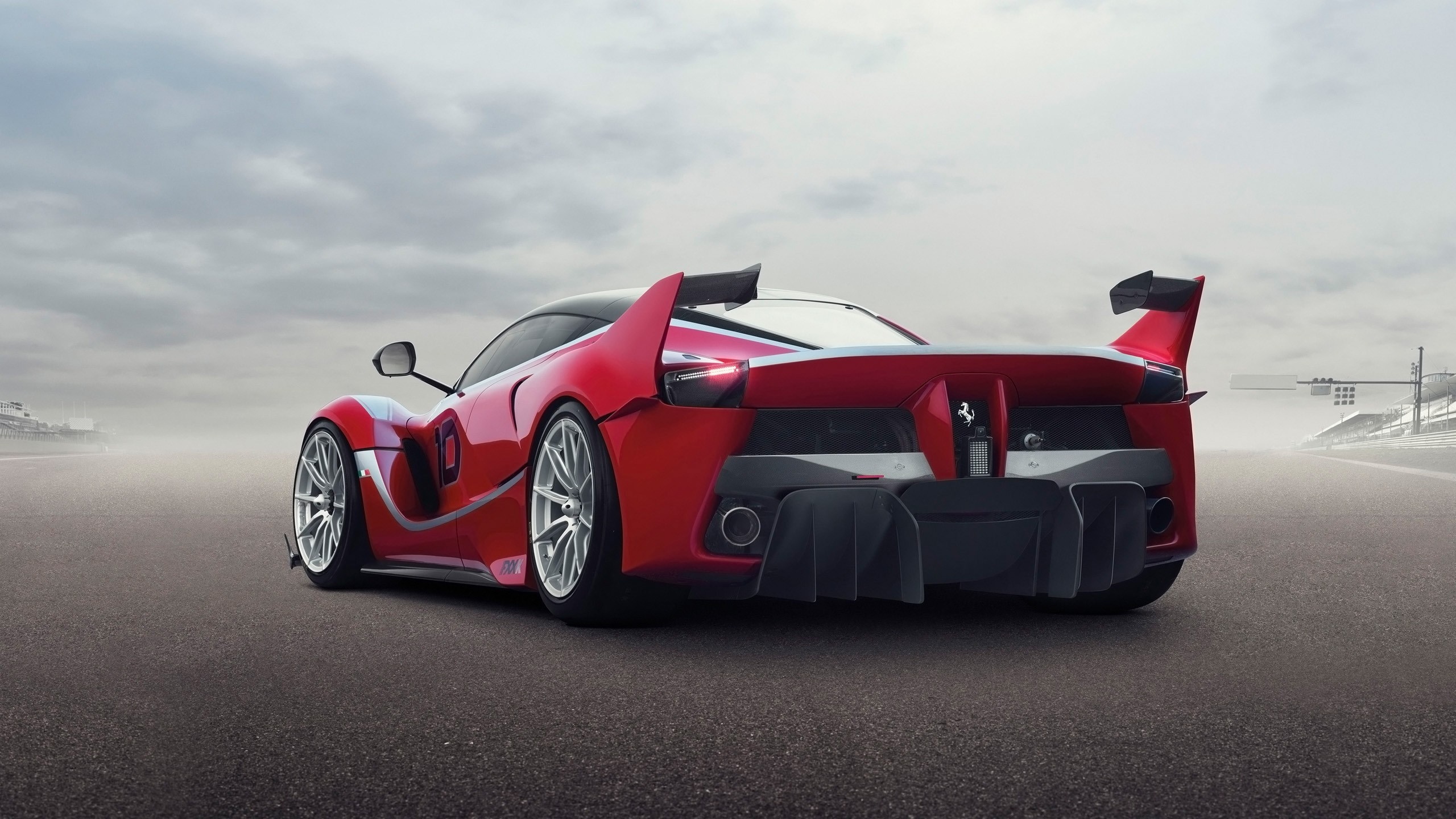 Red Ferrari FXX K race car on a track HD Wallpaper