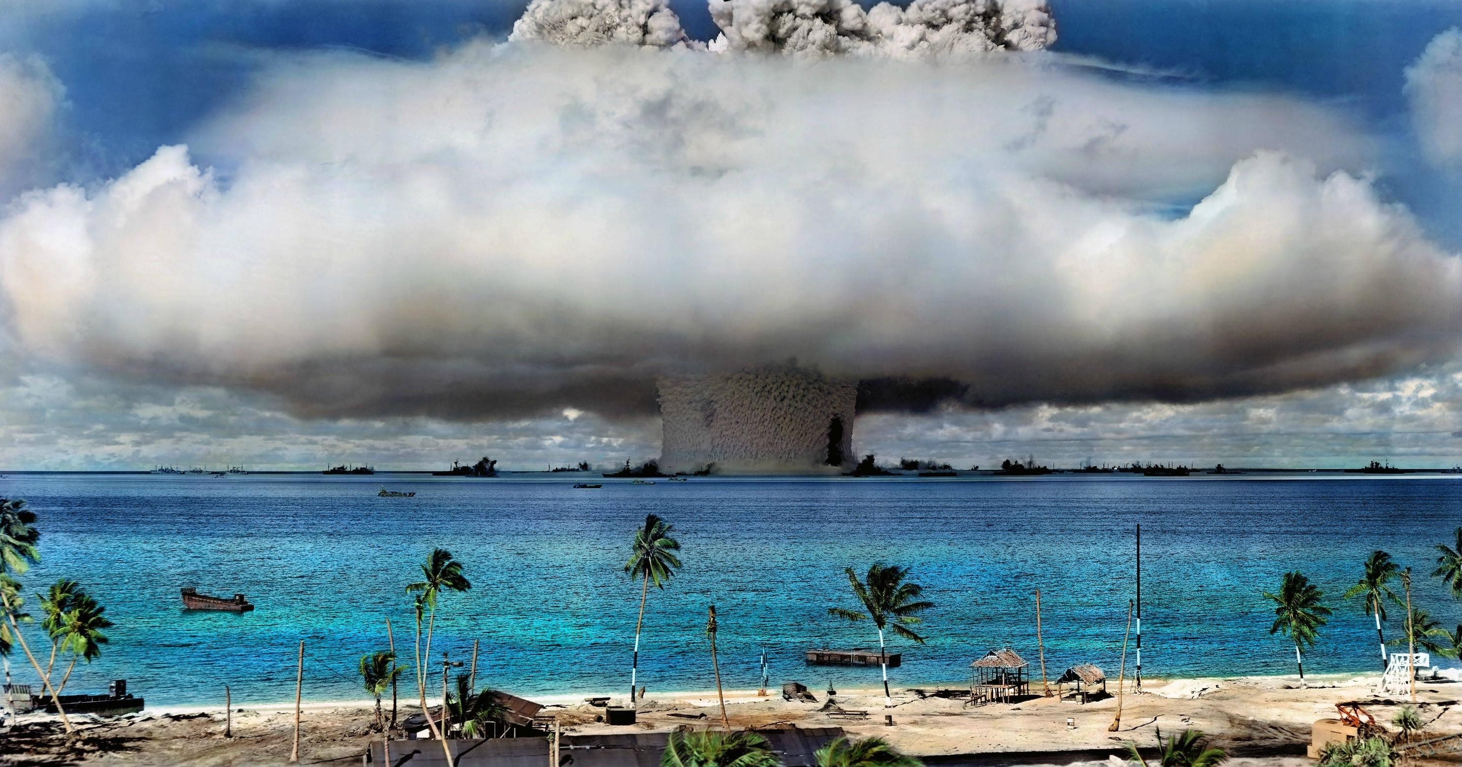 Nuclear explosion over the ocean with ships and palm trees HD Wallpaper