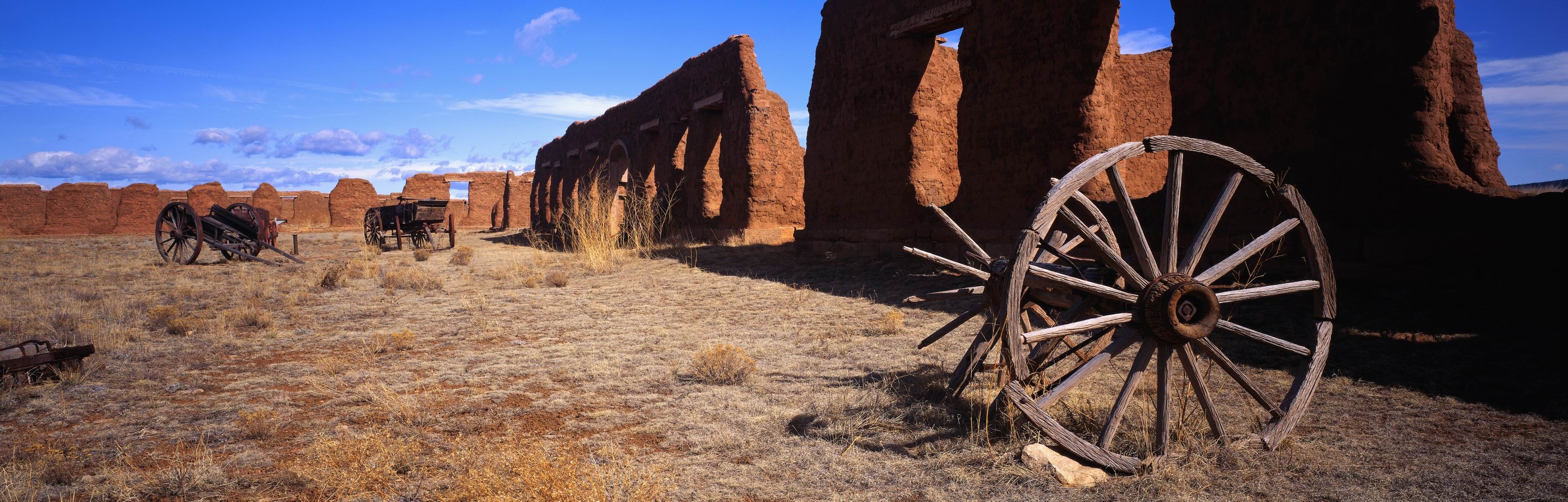 Ruins of an adobe fort with wagon wheels HD Wallpaper