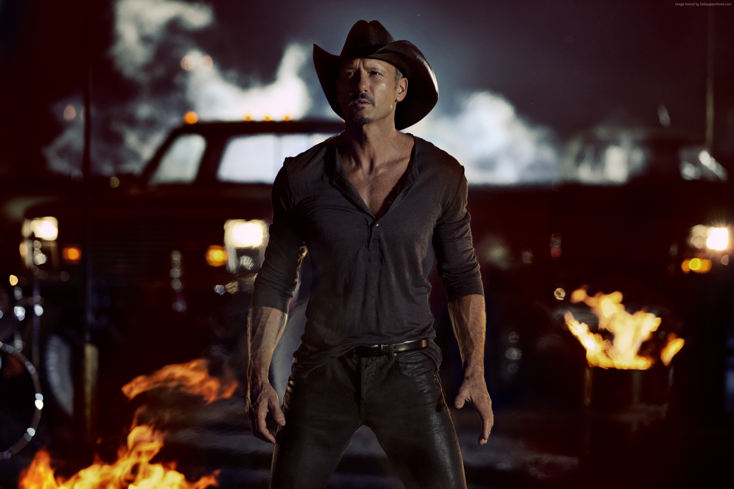Tim McGraw in a cowboy hat with fires and trucks HD Wallpaper