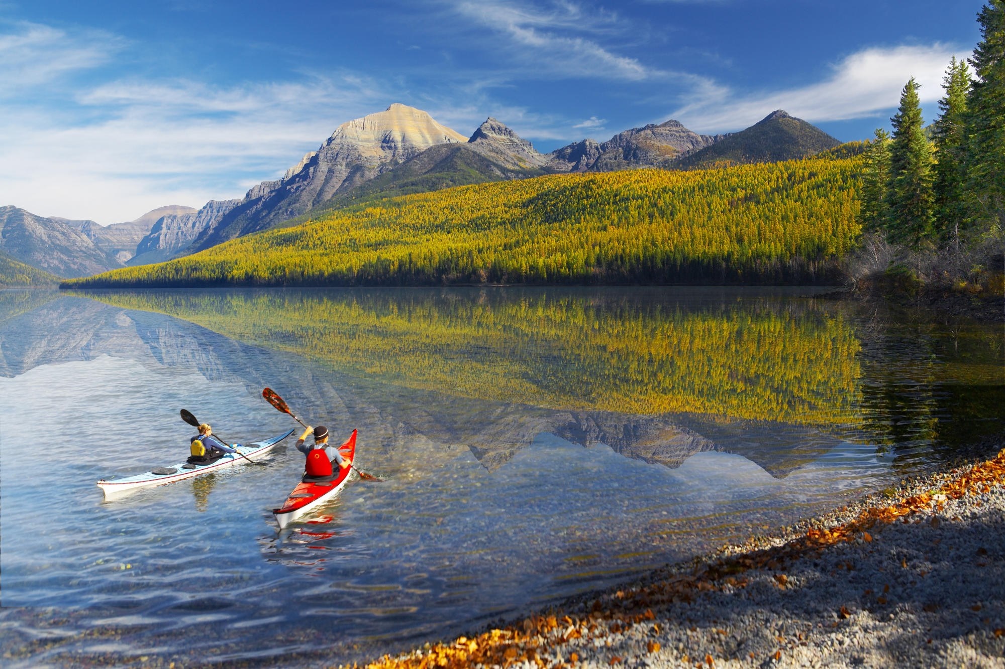 Kayakers on a lake with mountains and autumn trees HD Wallpaper