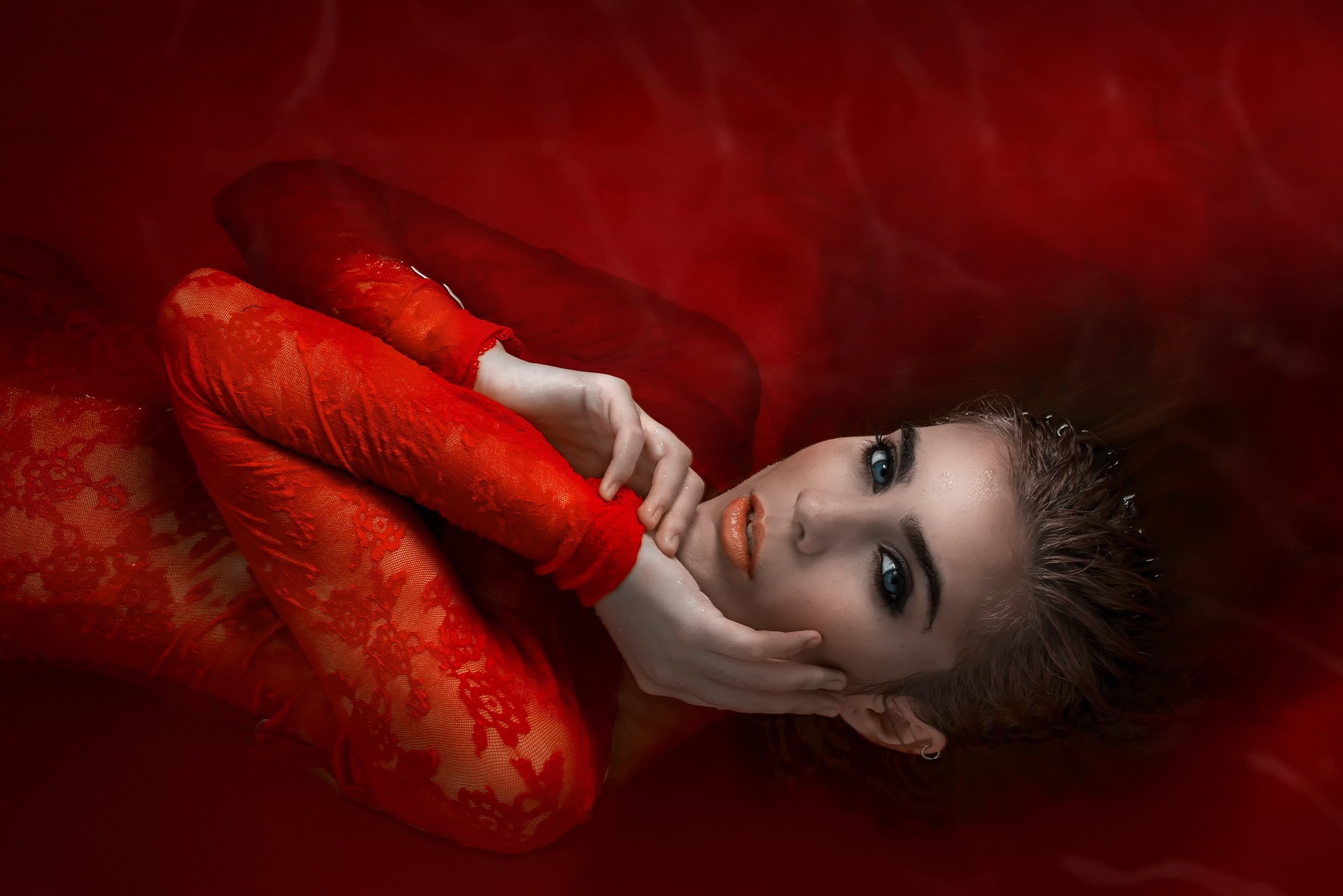 Woman in red lace dress submerged in red liquid HD Wallpaper