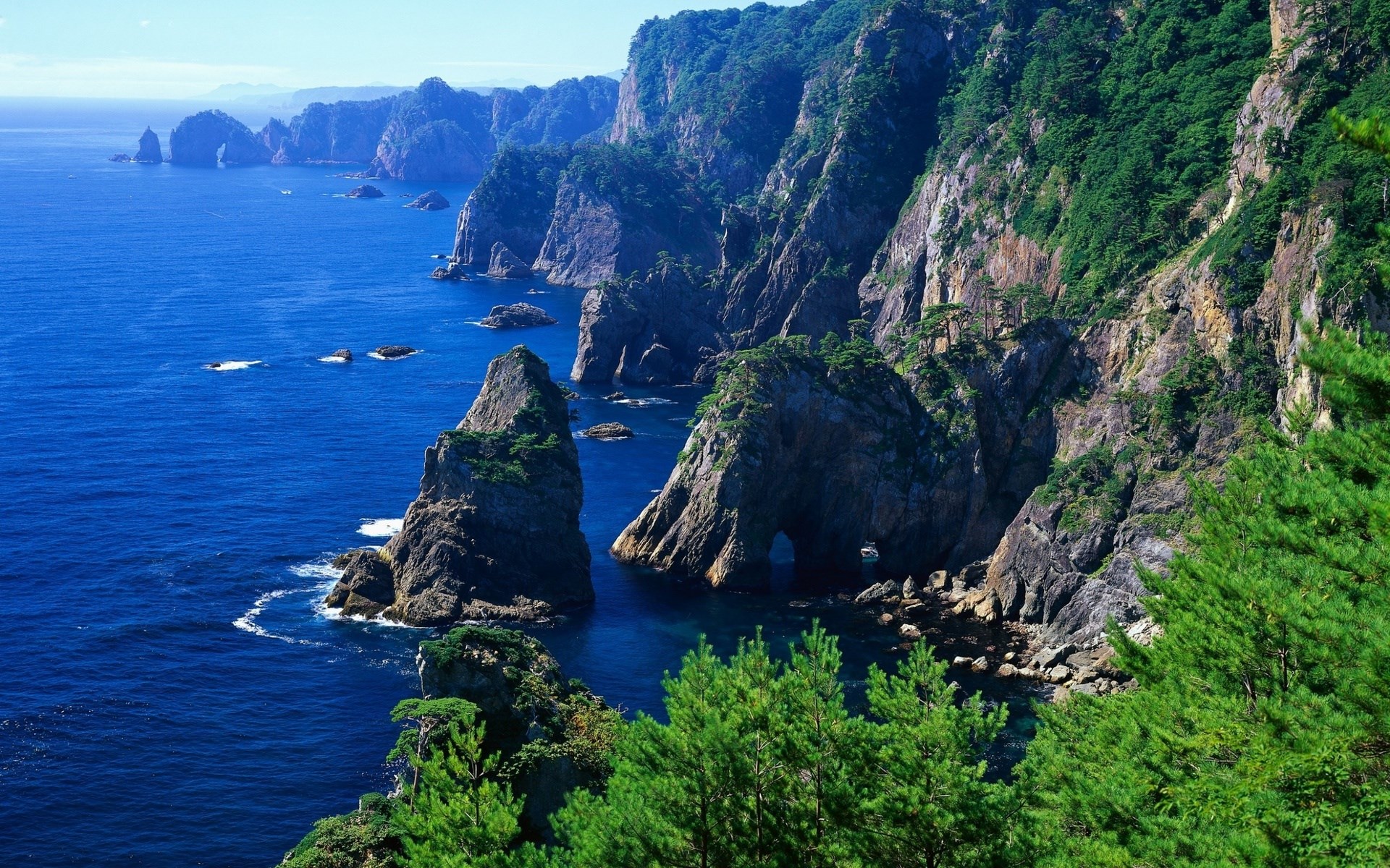 Rugged coastline with rocky islands and blue ocean HD Wallpaper