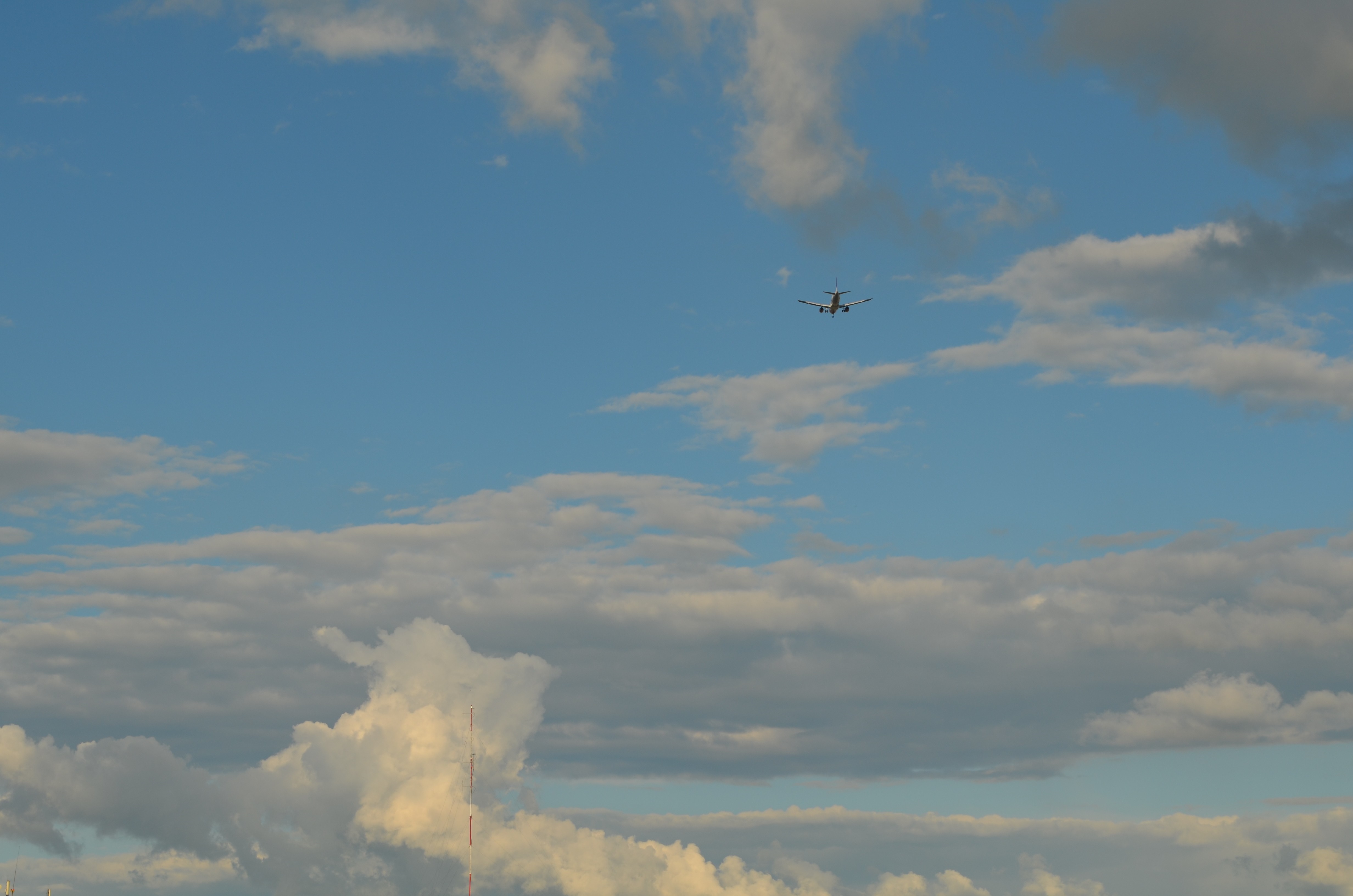 Airplane flying in a cloudy blue sky HD Wallpaper