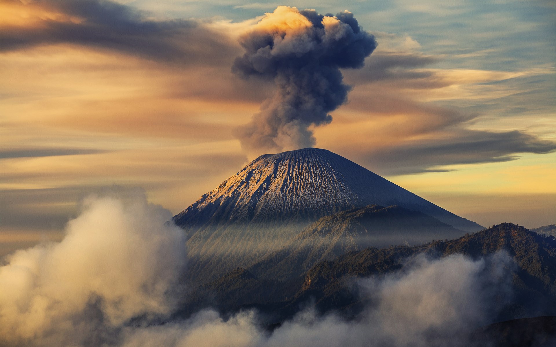 Volcano erupting with smoke and clouds at sunset HD Wallpaper