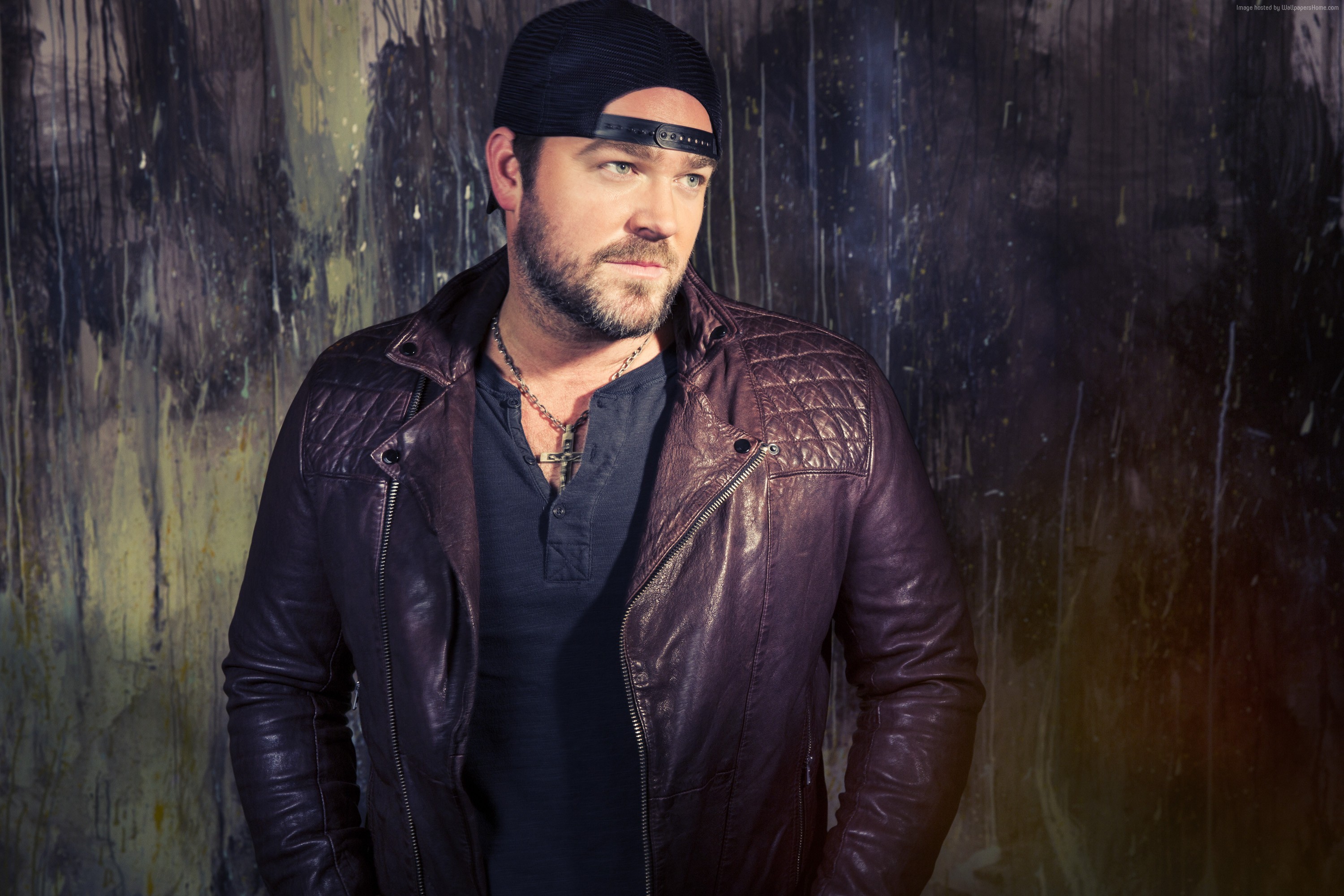 Lee Brice wearing a leather jacket and baseball cap HD Wallpaper