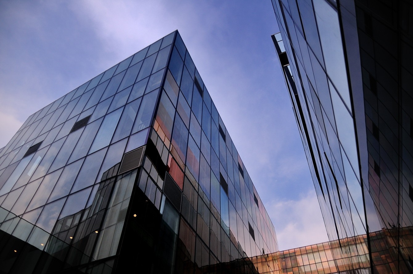 Modern glass buildings against a blue sky HD Wallpaper