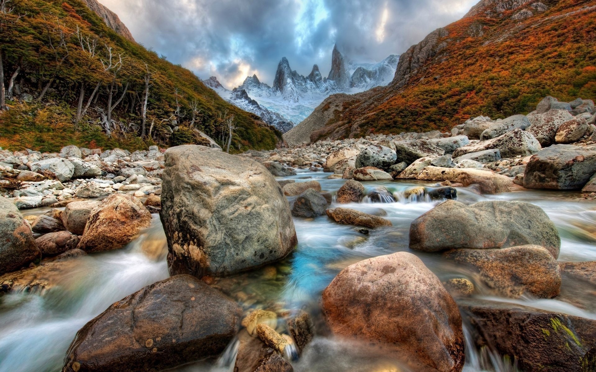 Mountain river with rocky banks and jagged peaks HD Wallpaper